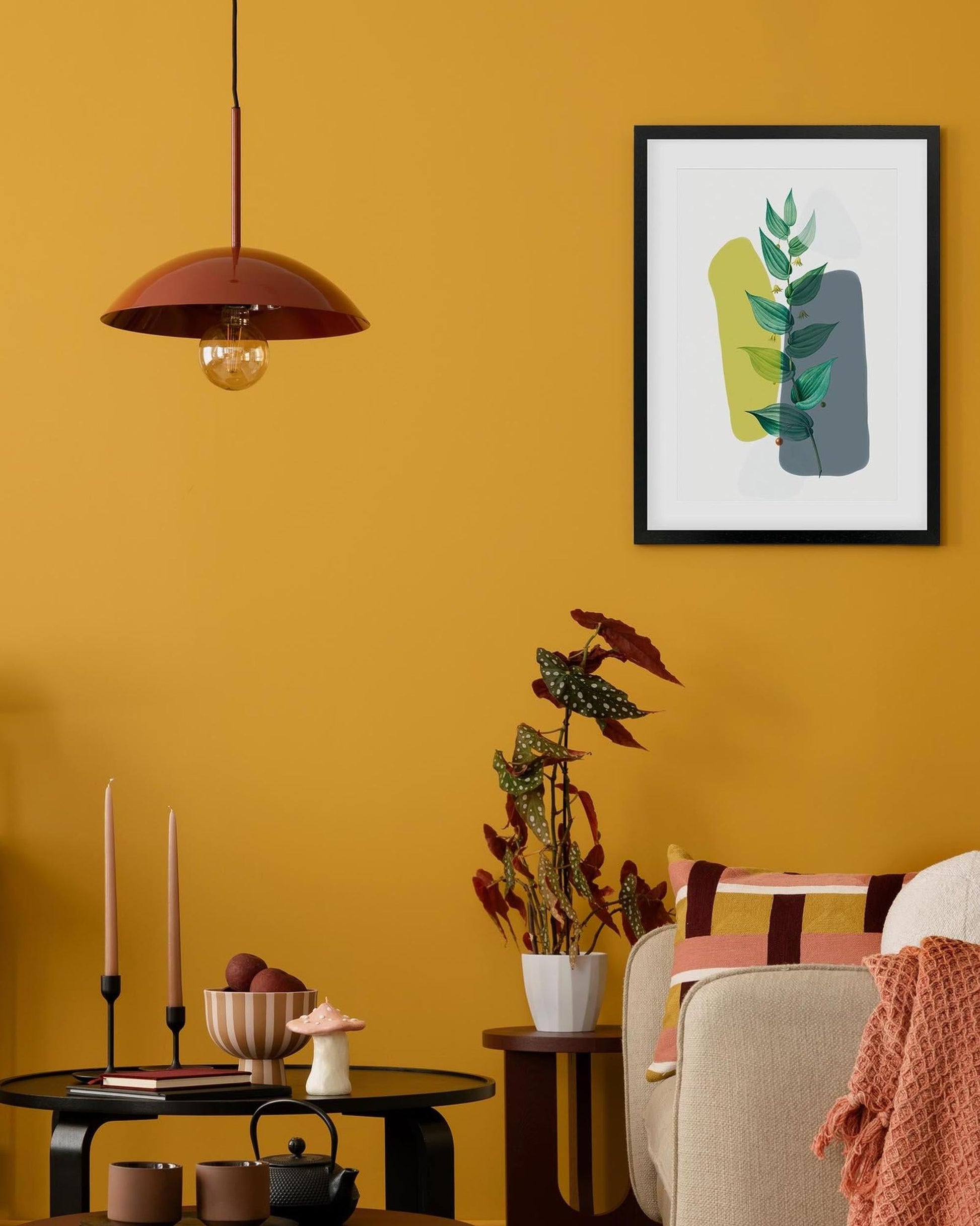 Living room with yellow walls, a framed abstract art piece, and decorative items.