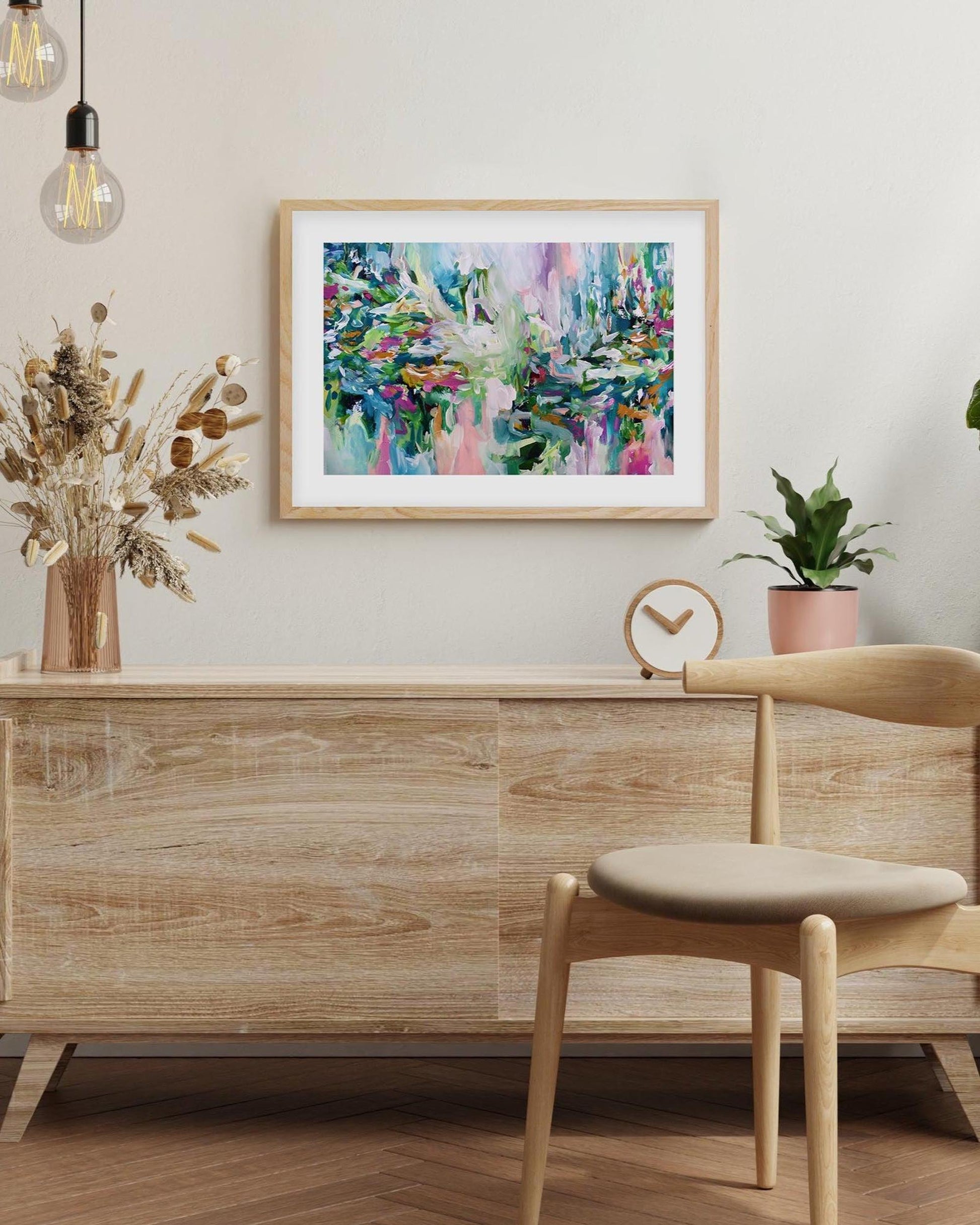 Wooden sideboard with a chair, abstract painting, and plants in a room.