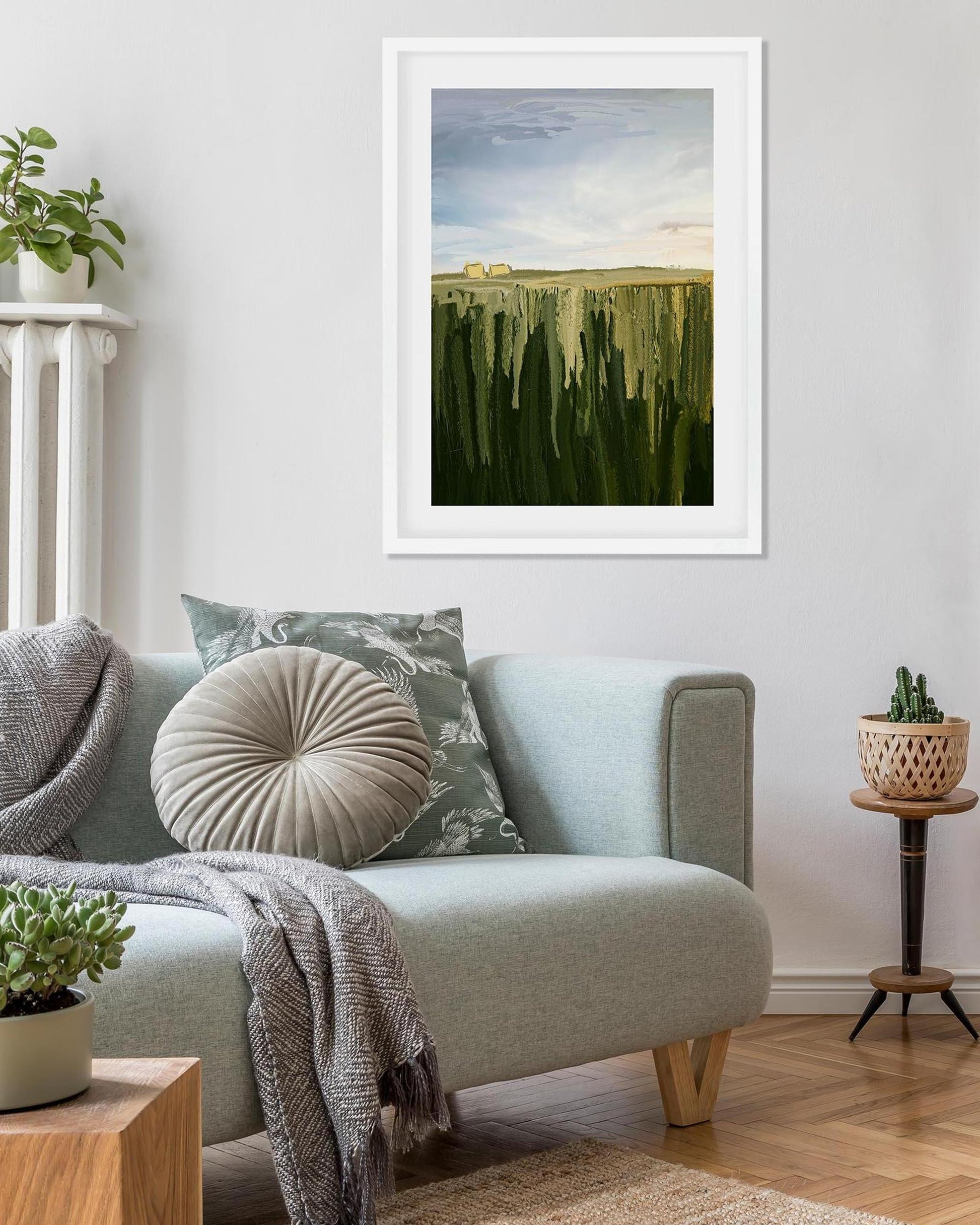 Living room with a sofa, cushions, and a framed abstract painting on the wall.
