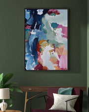 Colorful abstract painting on a dark green wall above a sofa with decorative pillows.