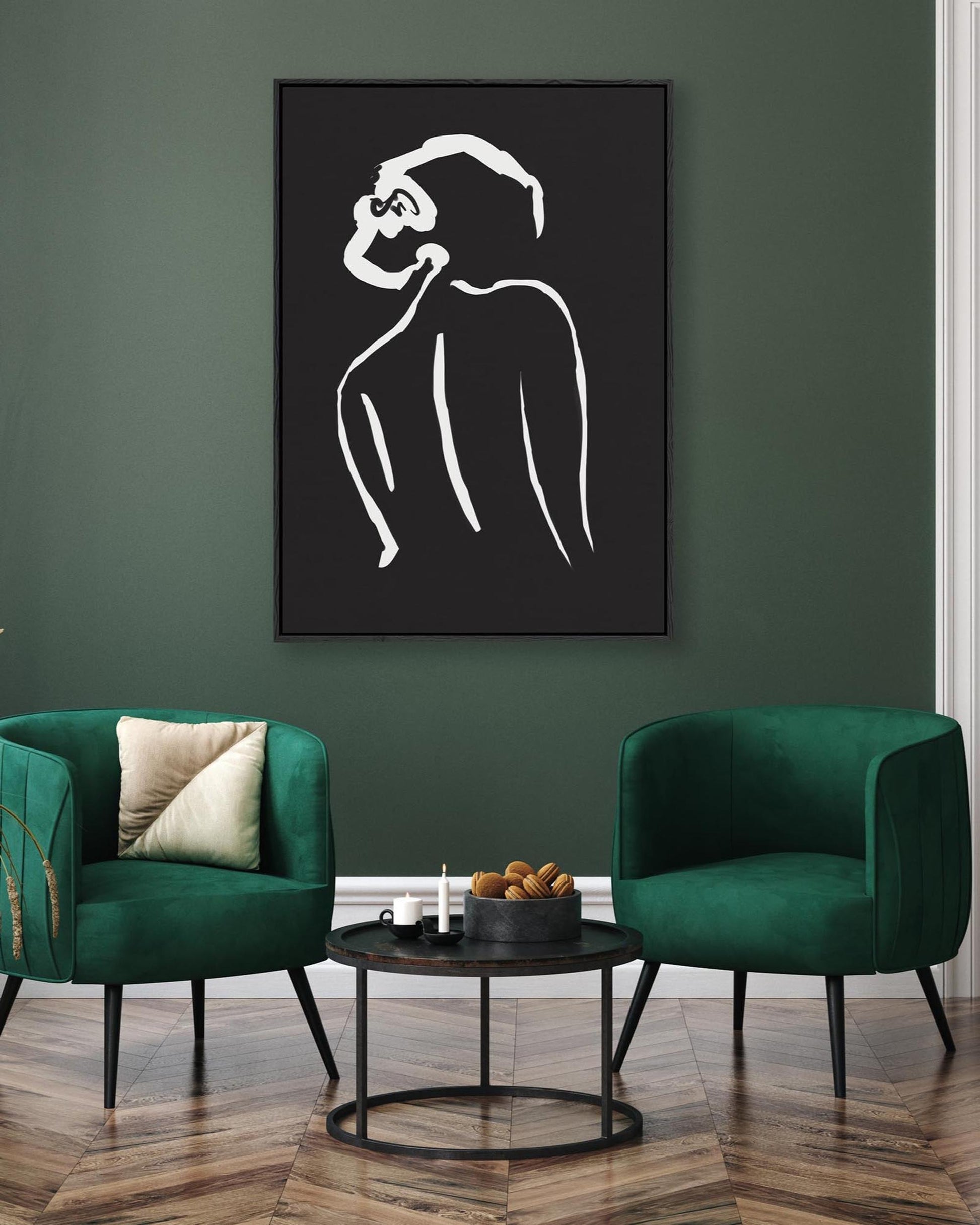 Modern living room with green chairs and a black and white abstract art piece on the wall.
