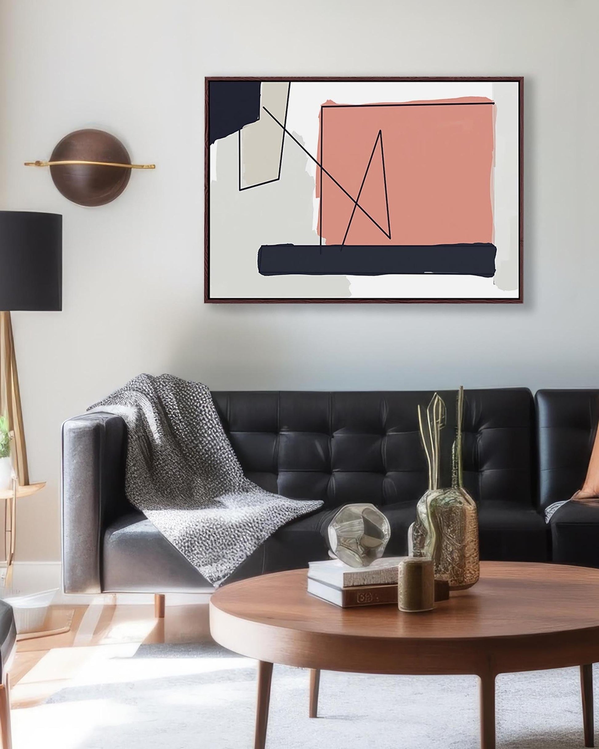 Modern living room with a black sofa, abstract art, and decorative items.