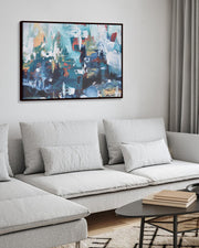 Modern living room with a gray sectional sofa, abstract painting, and decorative items.