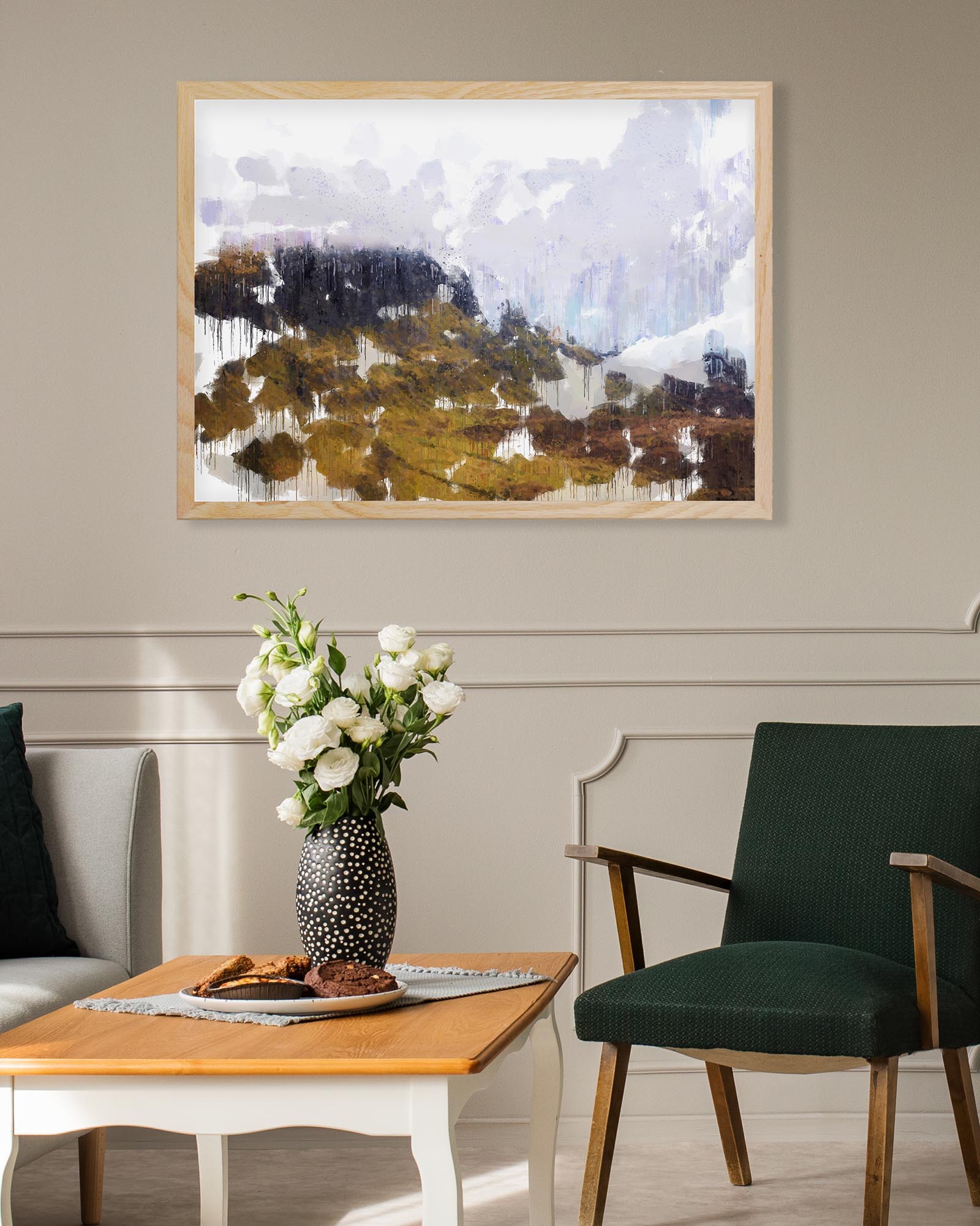 Living room with a framed abstract landscape painting, green chair, wooden table, and vase with flowers.
