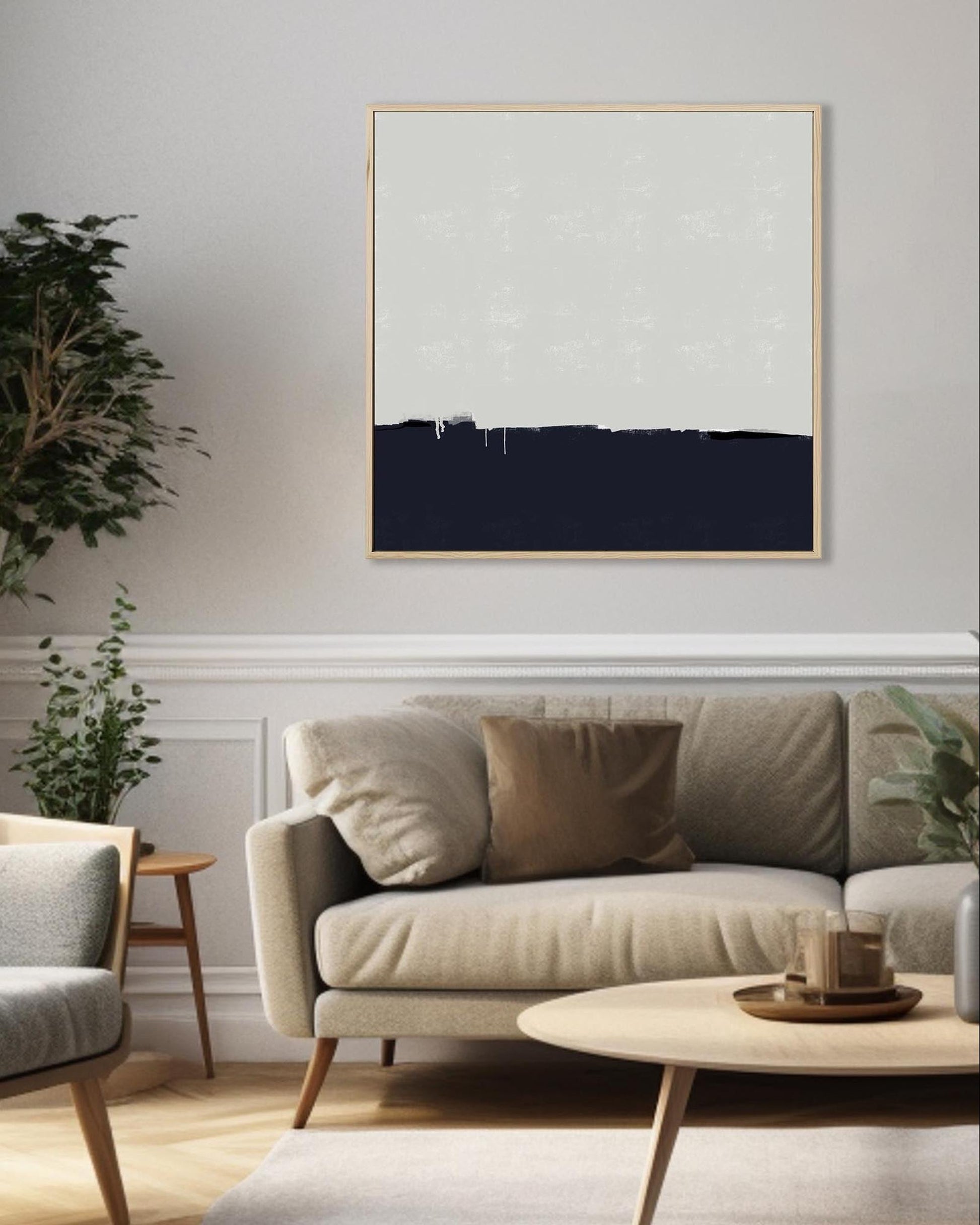 Modern living room with a neutral color scheme, featuring a sofa, coffee table, and abstract art on the wall.