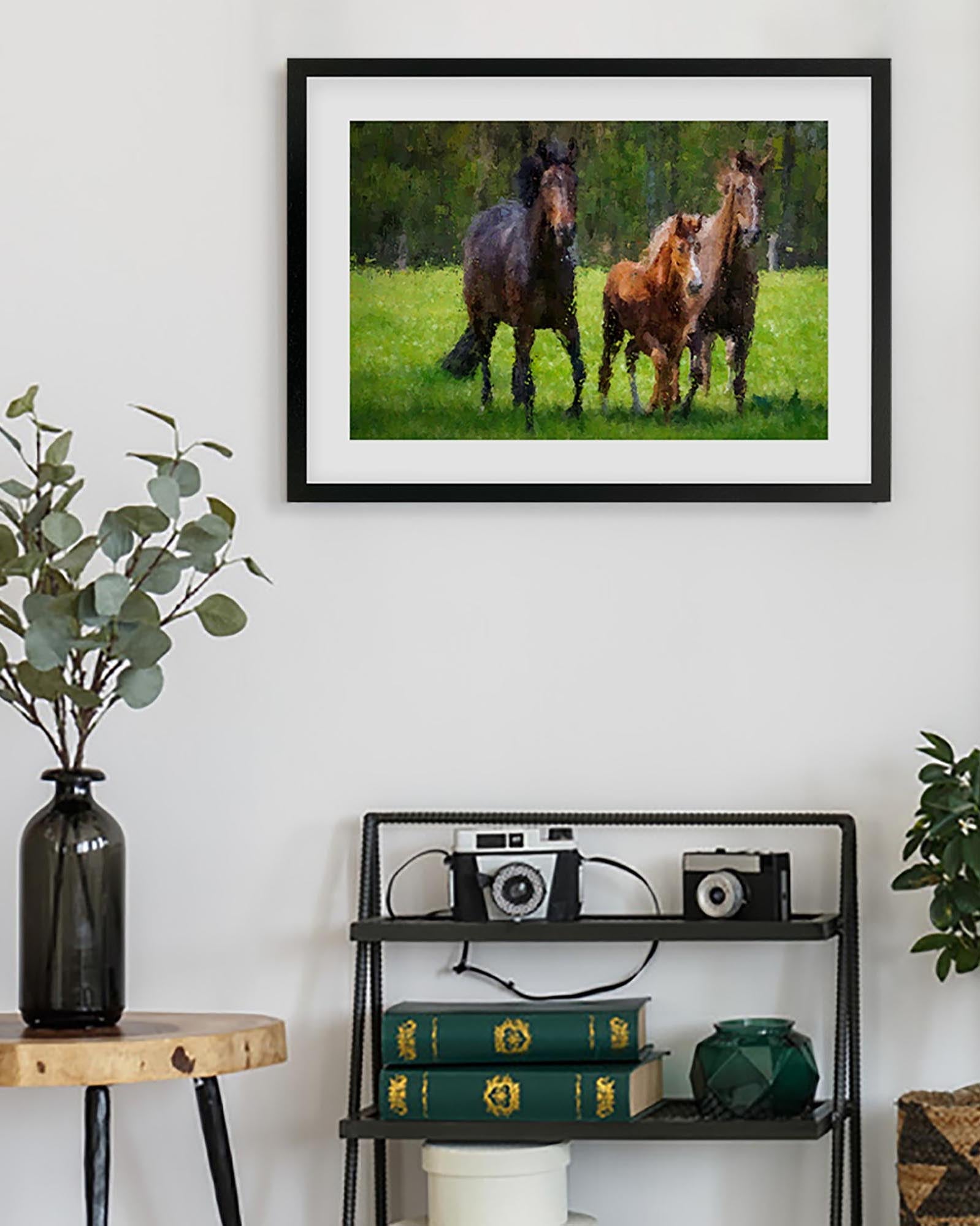 Framed photograph of three horses in a field on a white wall above a shelf with decorative items.