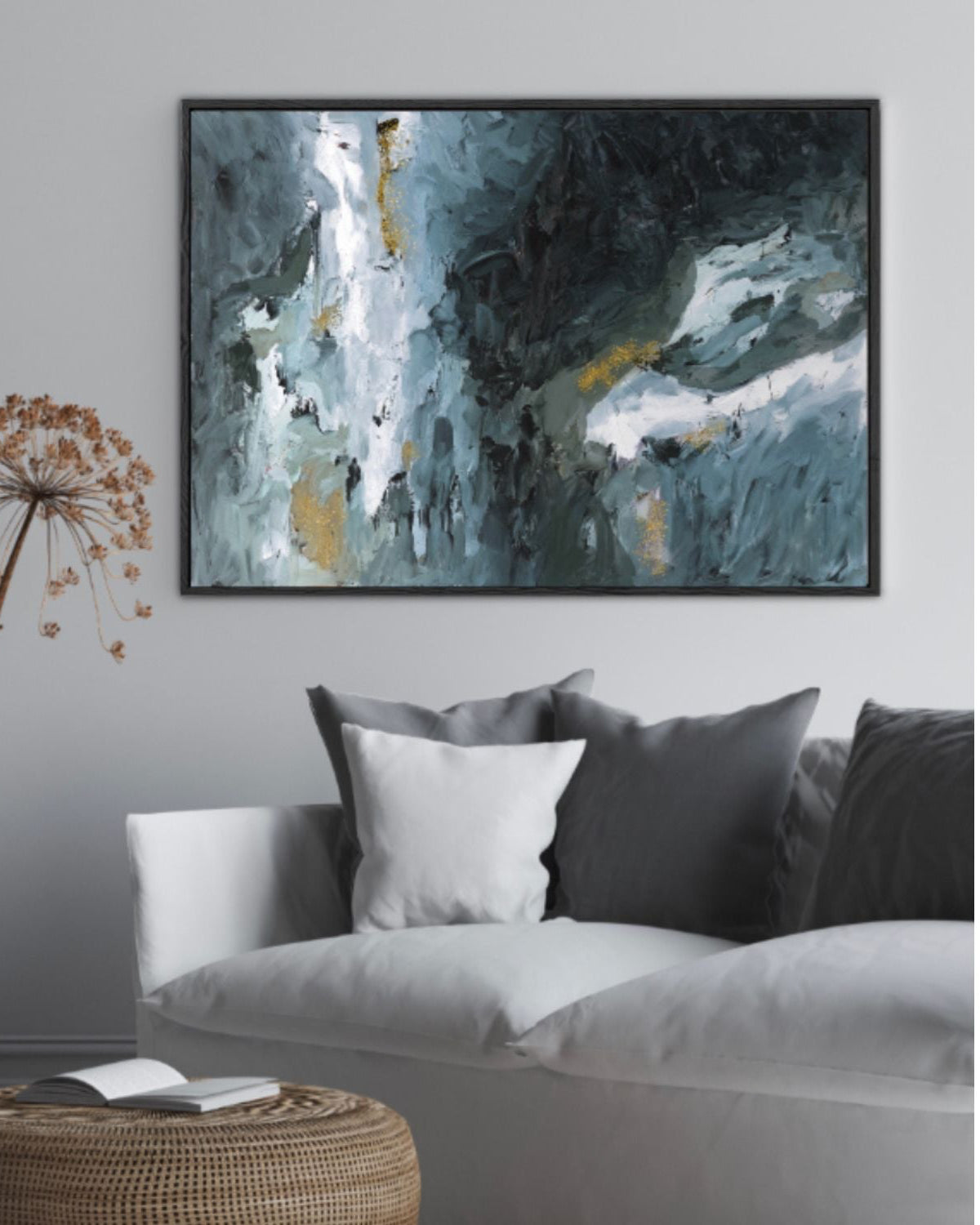 Living room with a gray sofa, abstract painting, and decorative elements.