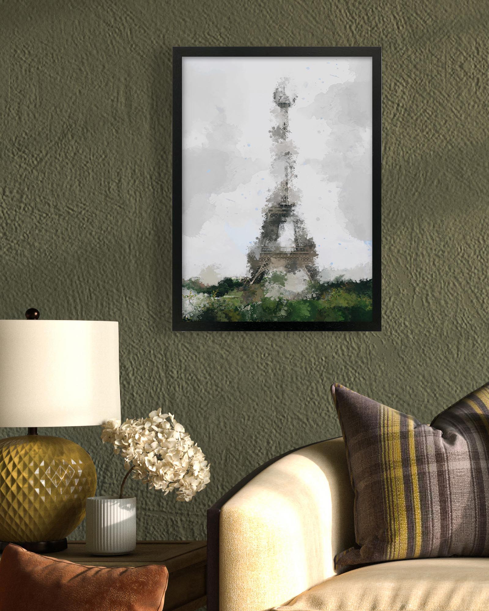 Framed artwork of a tower on a green wall above a sofa with decorative pillows.