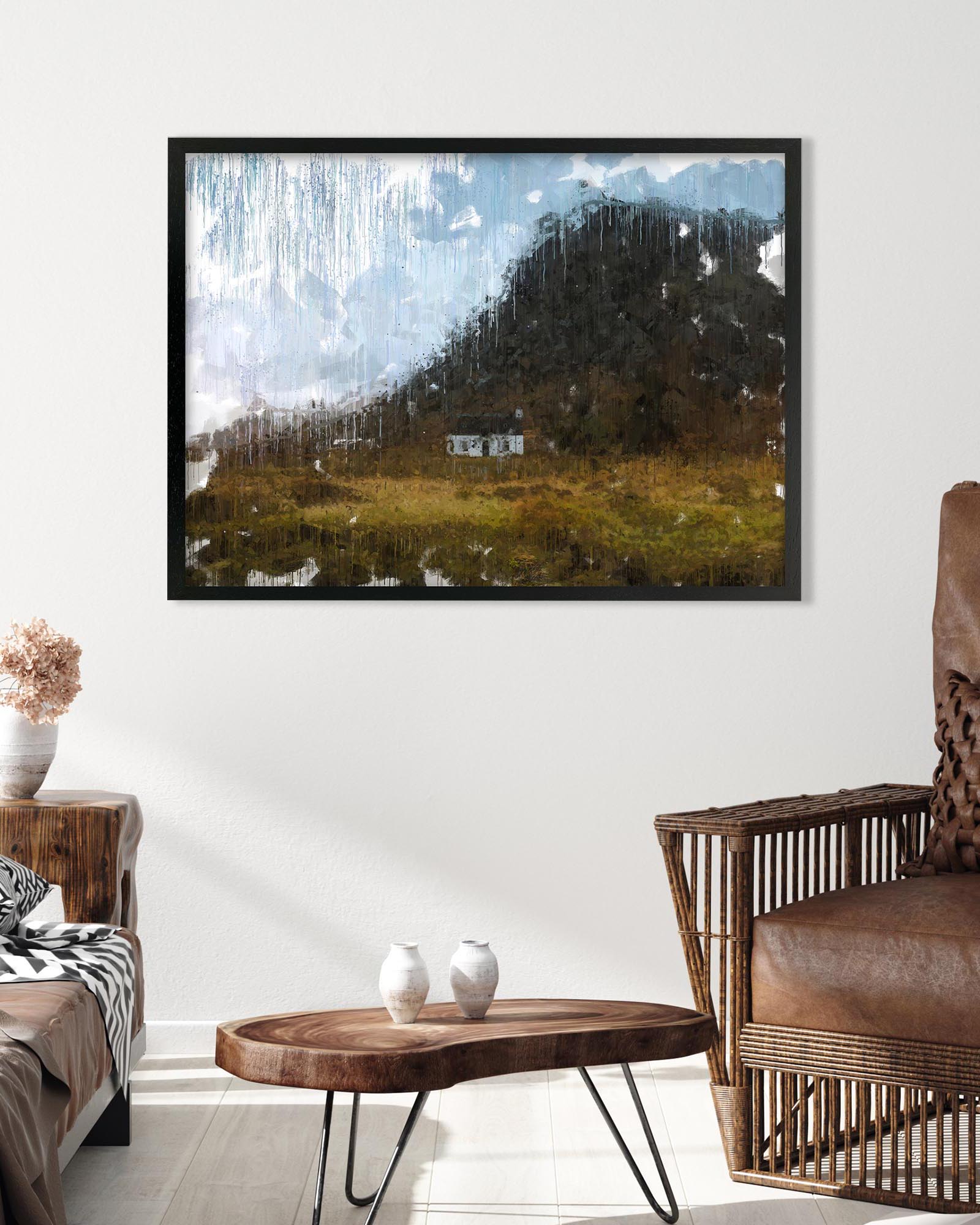 Framed abstract artwork in a living room setting with a wicker chair and wooden coffee table.