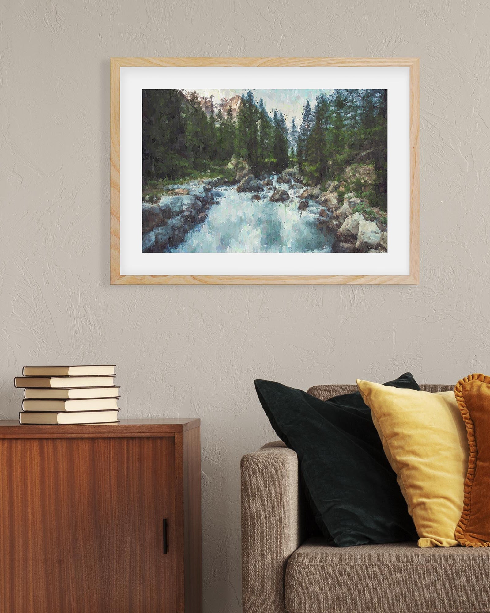 Framed nature print on a wall above a sofa with decorative pillows.