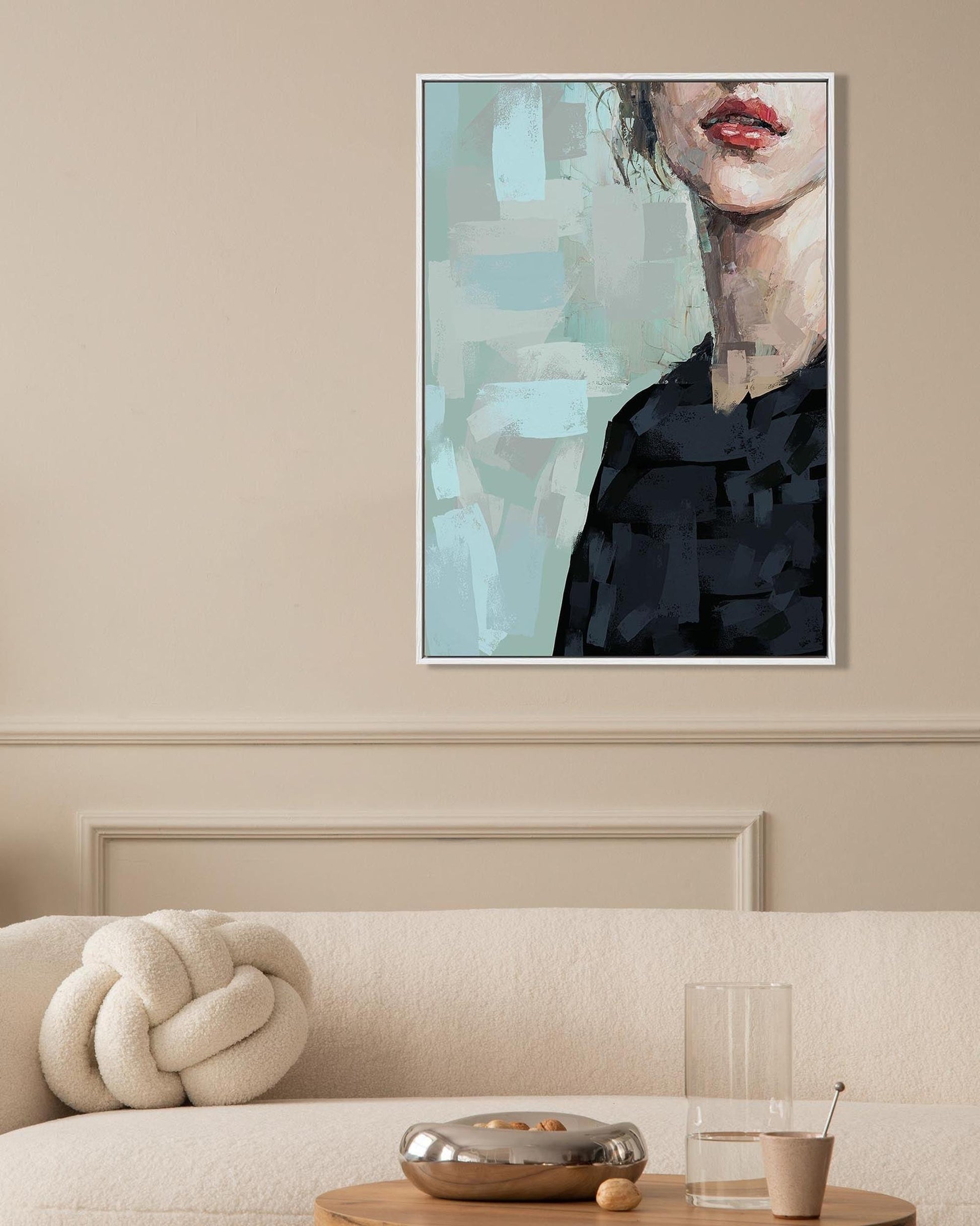 Framed abstract art above a beige sofa with decorative items.