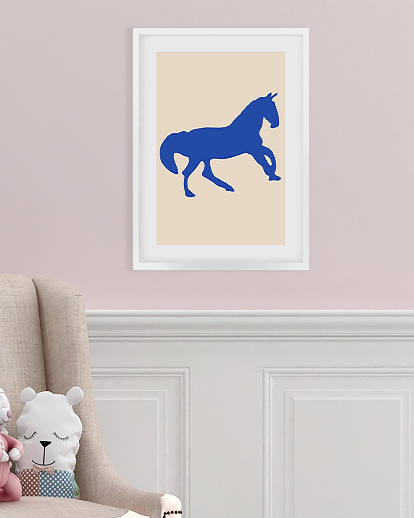 Framed artwork of a blue horse silhouette on a beige background, displayed in a room with a chair and stuffed toys.