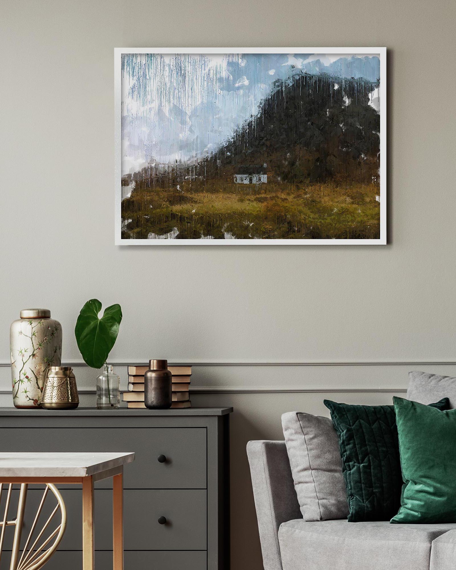 Framed landscape painting on a wall above a sofa and side table.