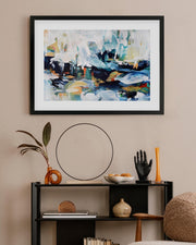 Framed abstract painting on a wall above a shelf with decorative items.