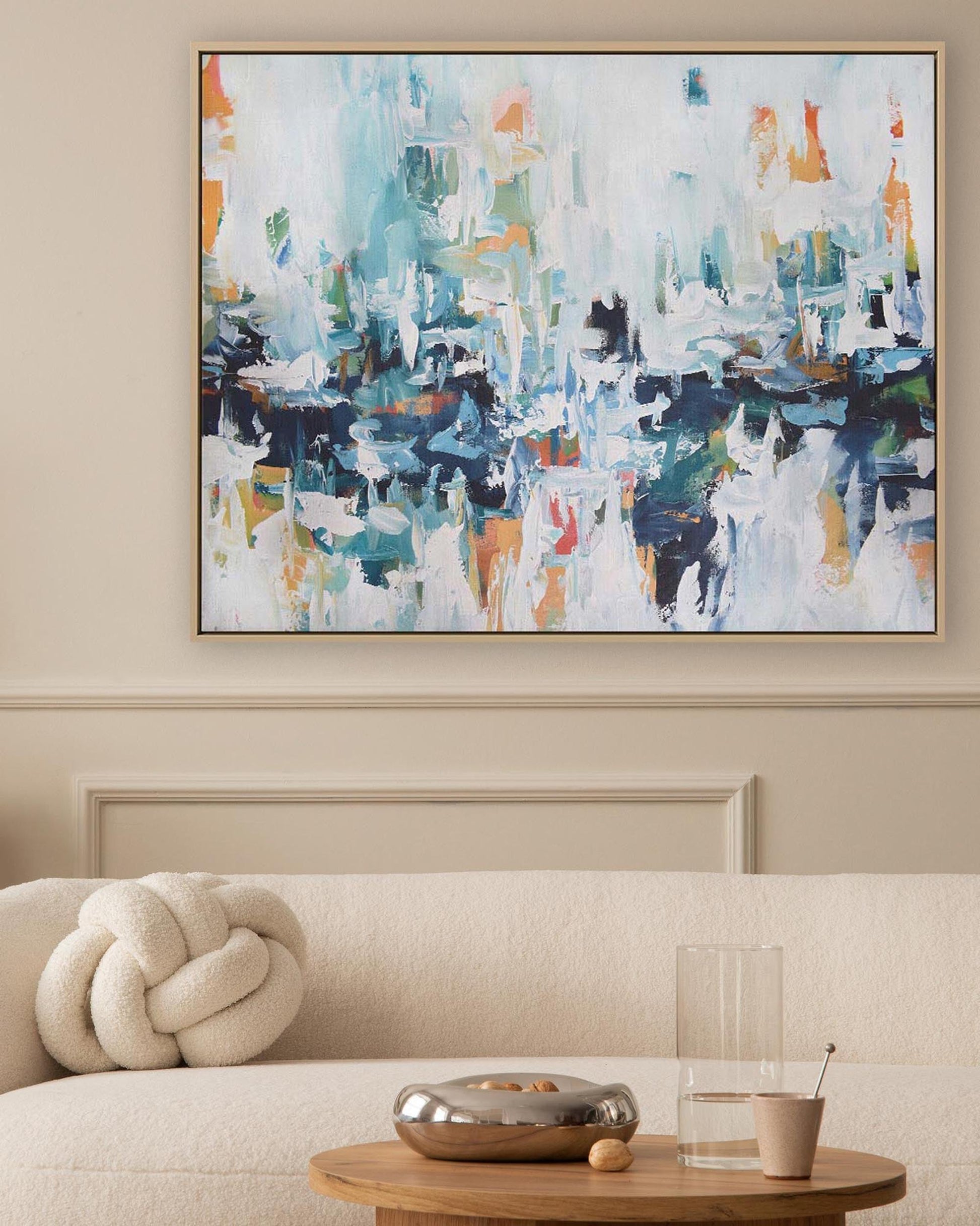 Abstract painting on a wall above a sofa in a living room