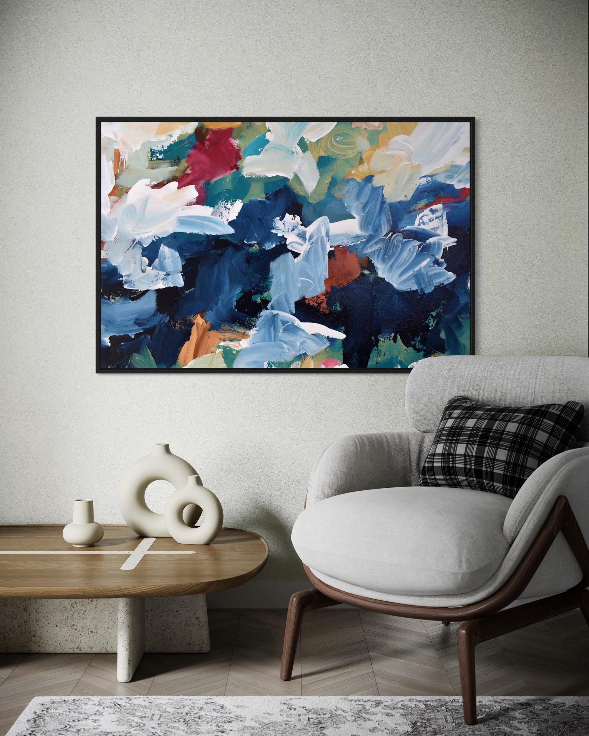 Modern living room with a colorful abstract painting, white armchair, and wooden coffee table.