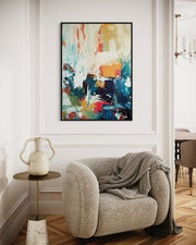 Modern interior with a colorful abstract painting on the wall, a textured armchair, and a small table.