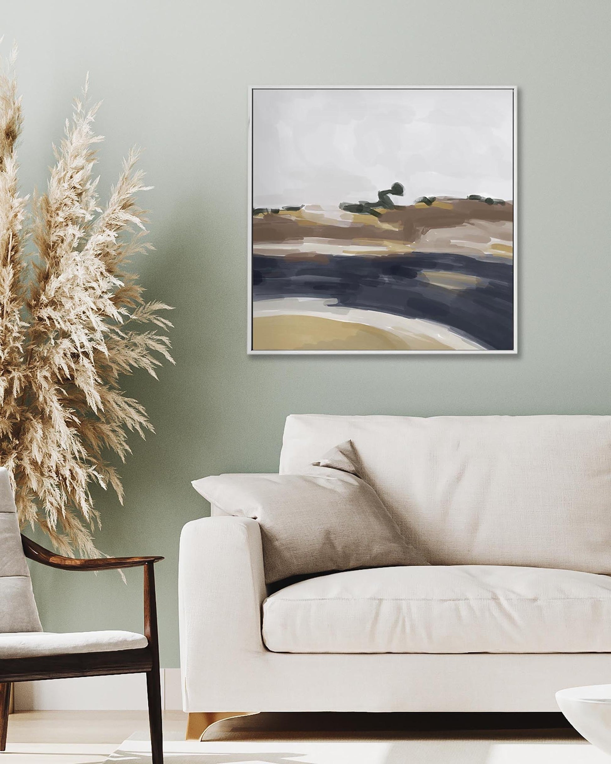 Modern living room with a beige sofa, armchair, and abstract painting on the wall.