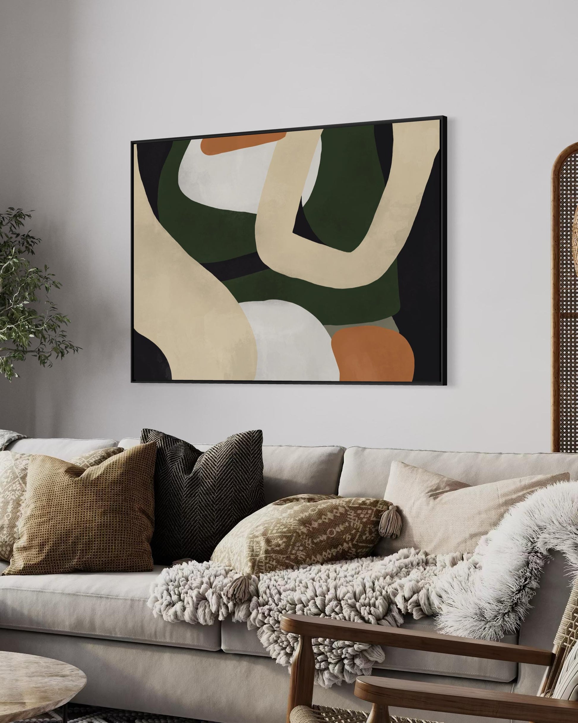 Abstract art piece on a wall above a sofa with decorative pillows.