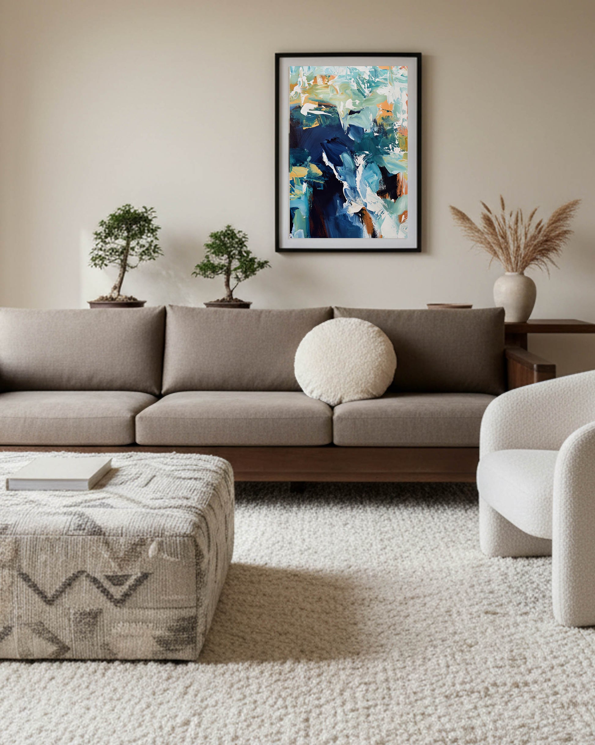 Modern living room with a gray sofa, abstract art, and decorative plants.