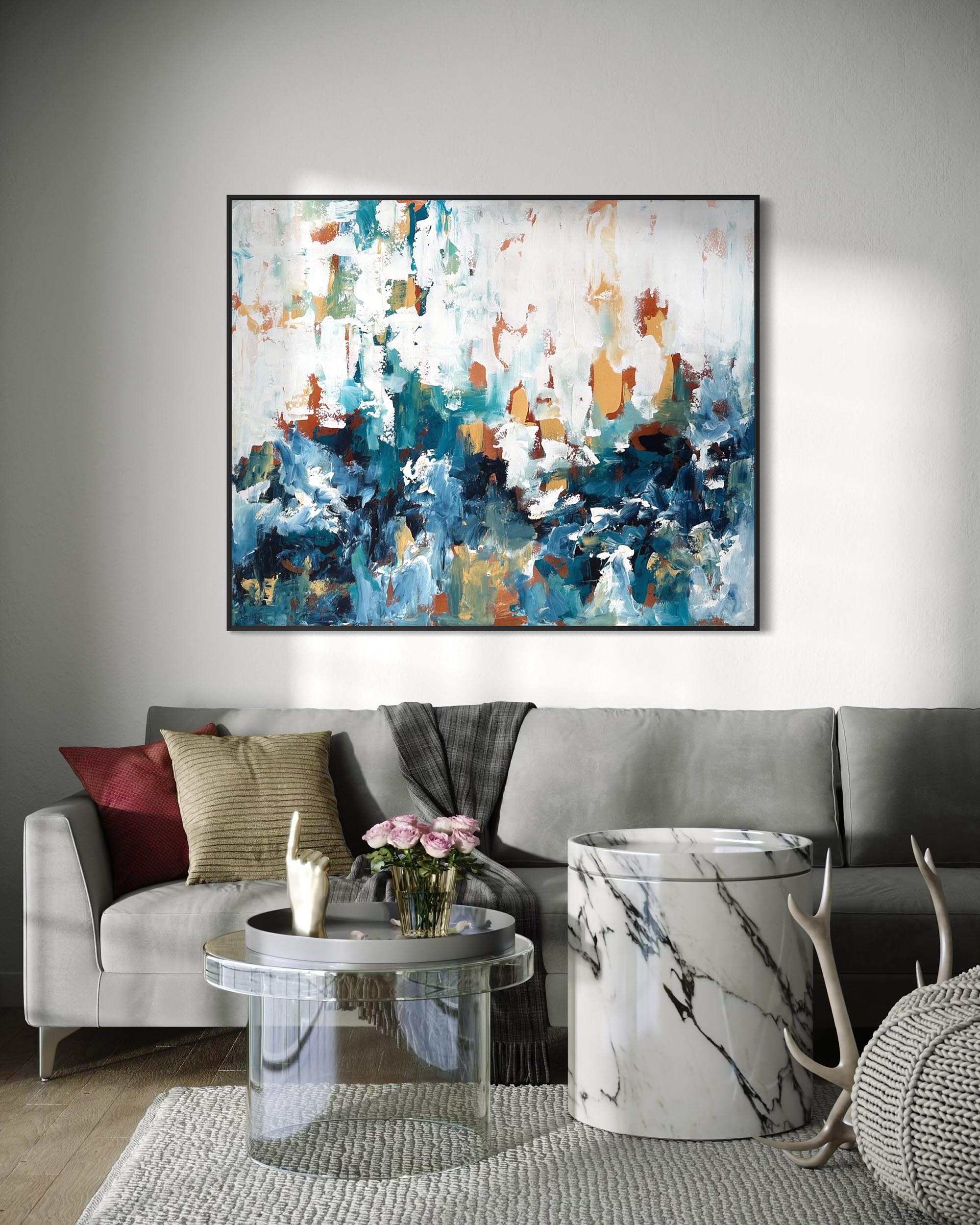 Living room with a gray sofa, coffee table, and abstract painting on the wall.