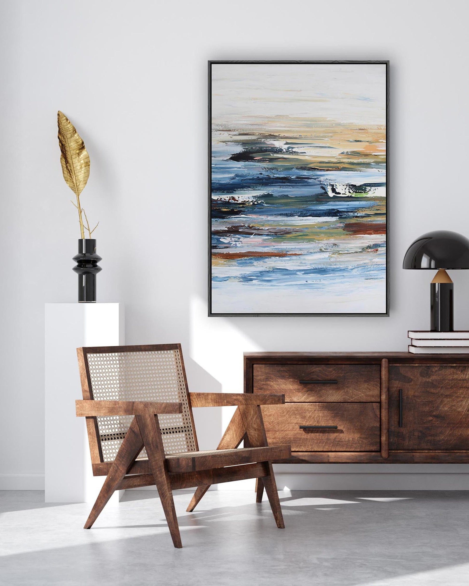 Modern interior with wooden chair, sideboard, and abstract painting on a white wall.