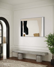 Modern interior with abstract art on the wall, stone bench, and plant.