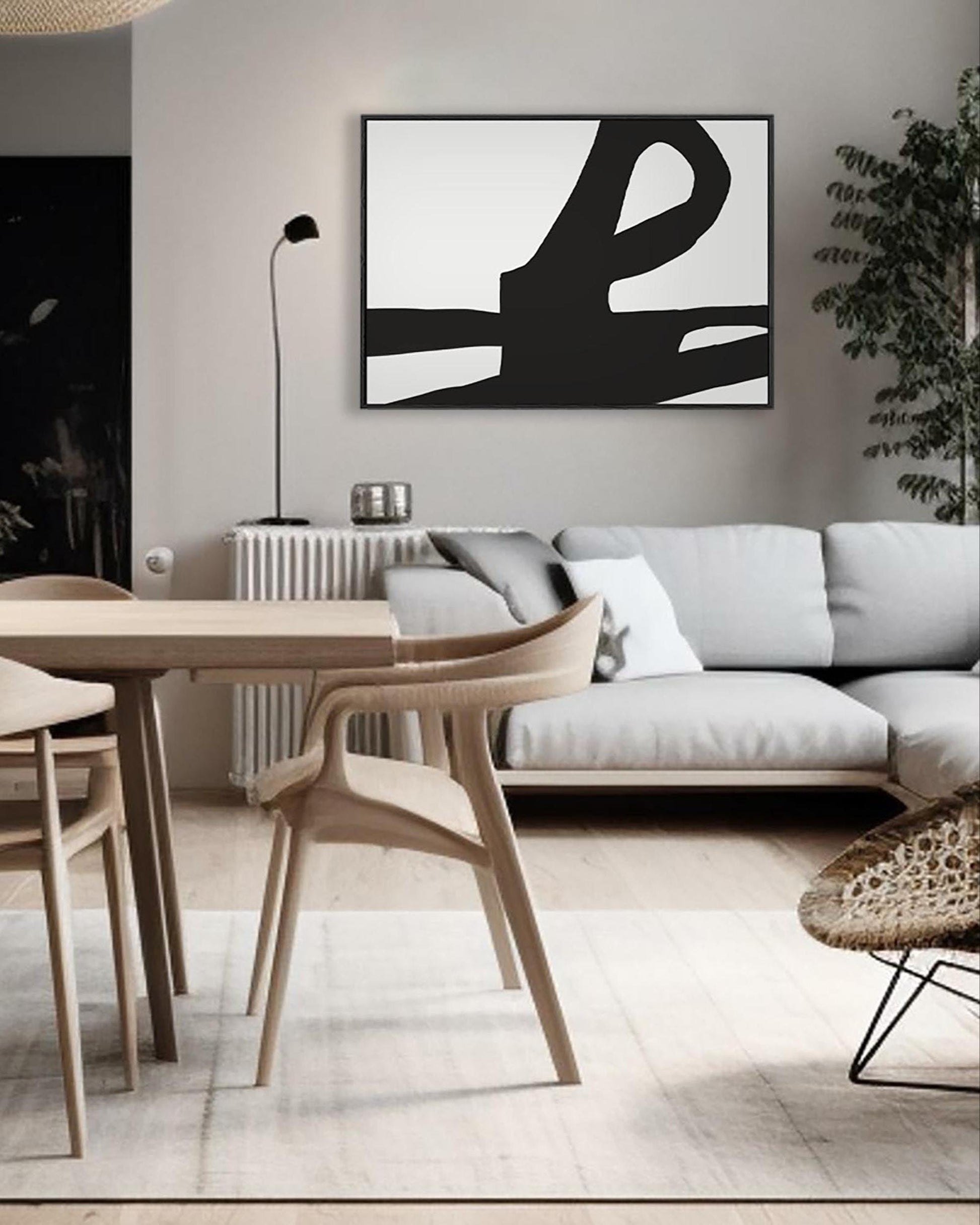 Modern living room with abstract art, sofa, and dining table.