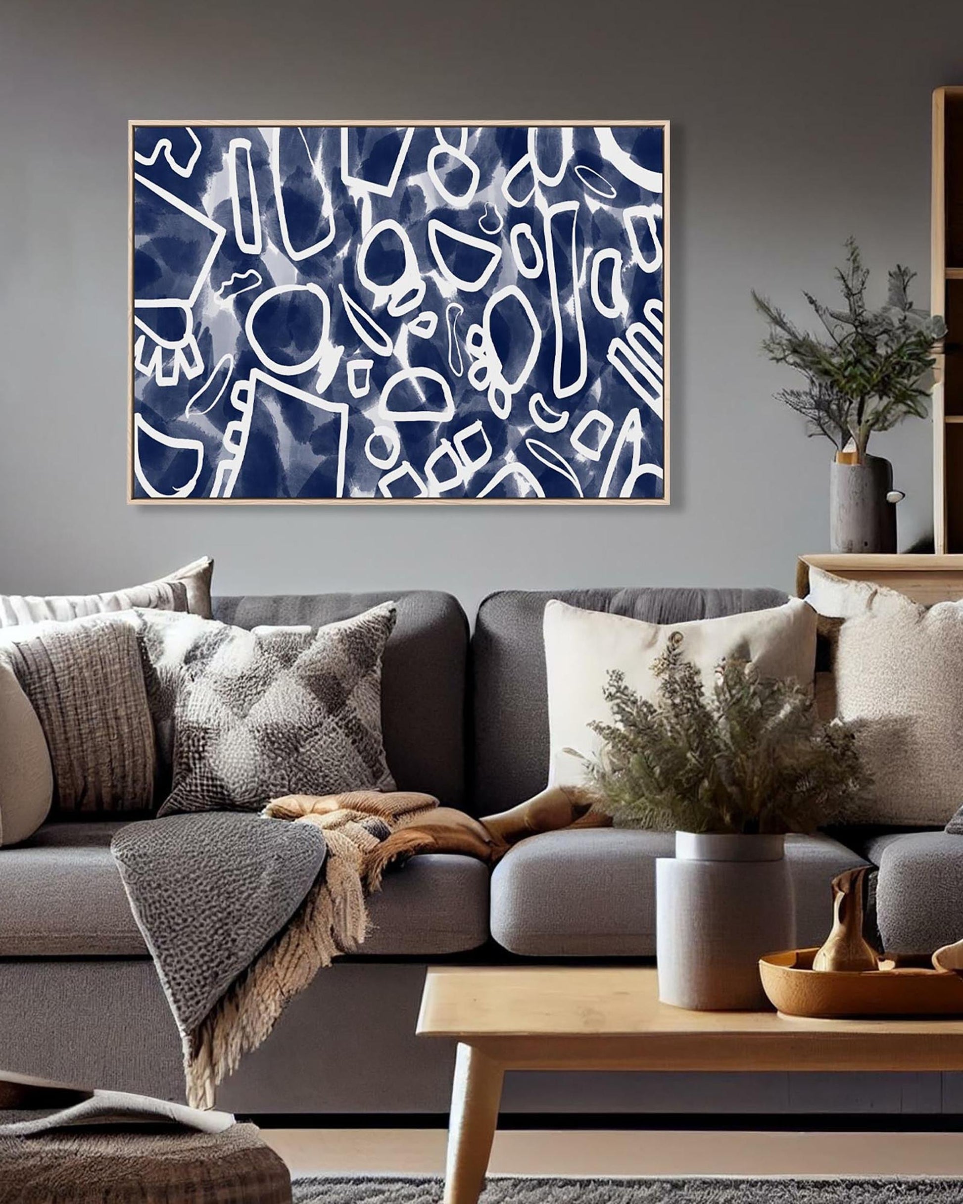 Living room with a gray sofa, abstract art on the wall, and decorative elements.