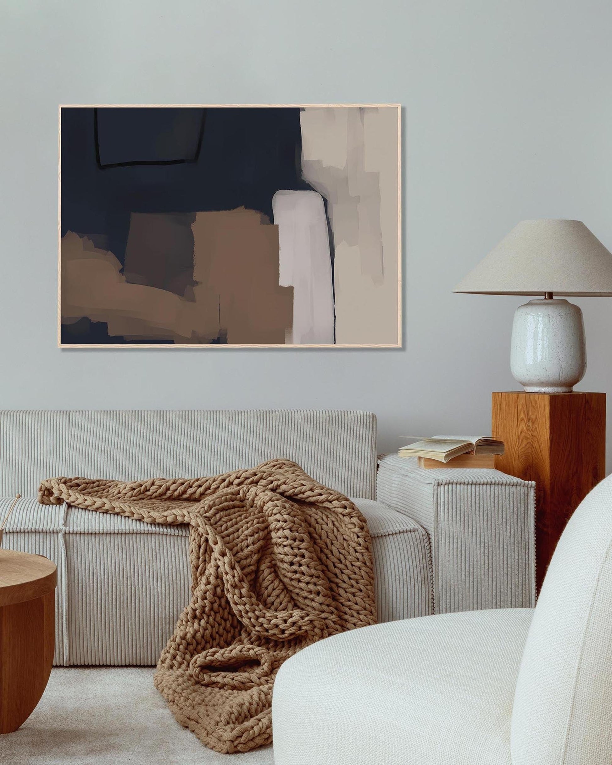 Cozy living room with a beige sofa, abstract art, and a lamp.