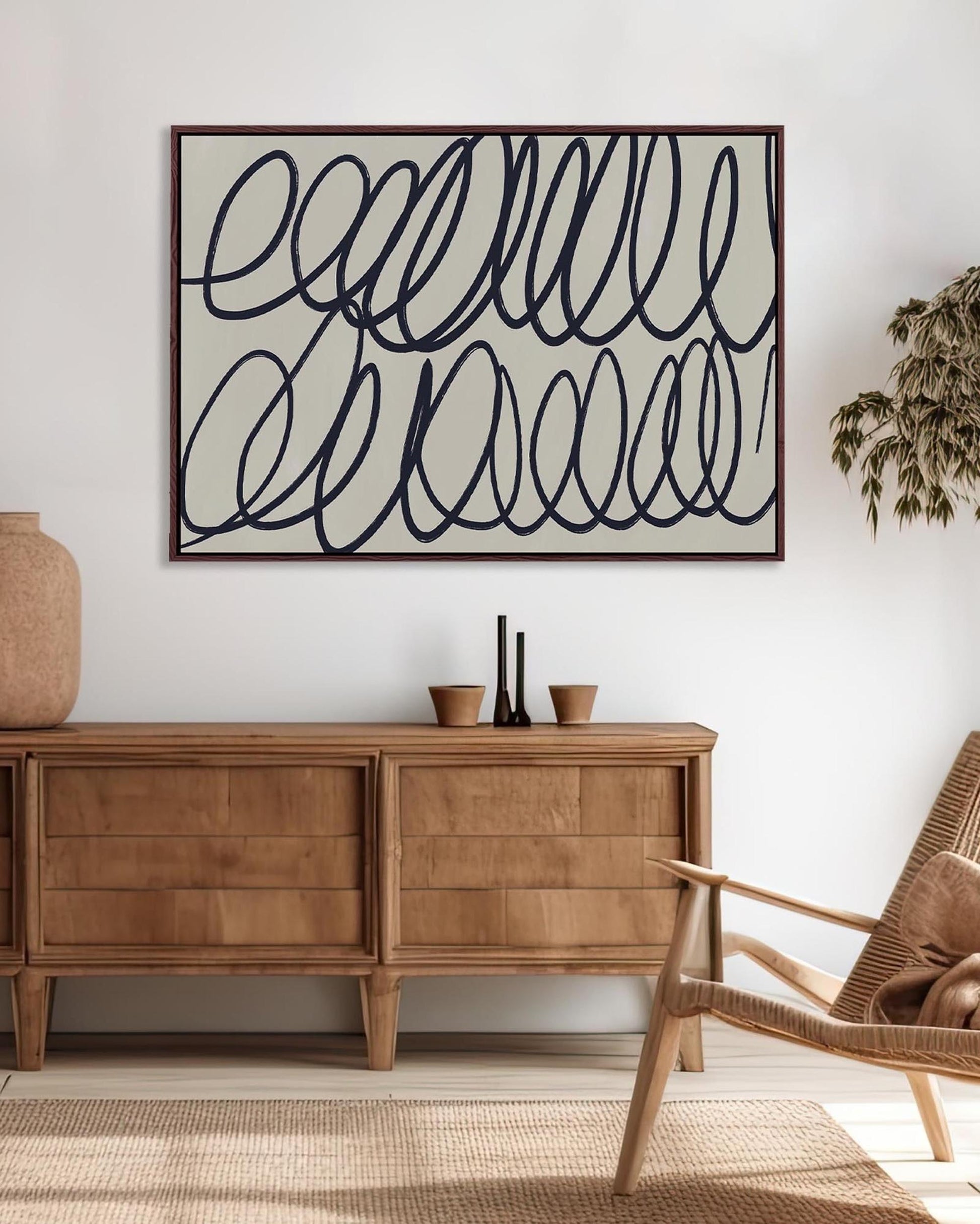 Living room with wooden sideboard, wicker chair, and abstract wall art.
