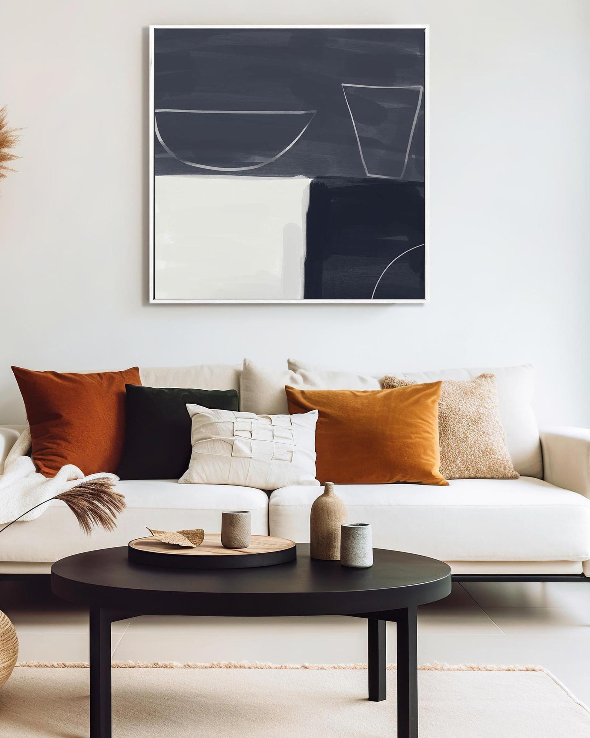Modern living room with a white sofa, decorative pillows, and a black coffee table.