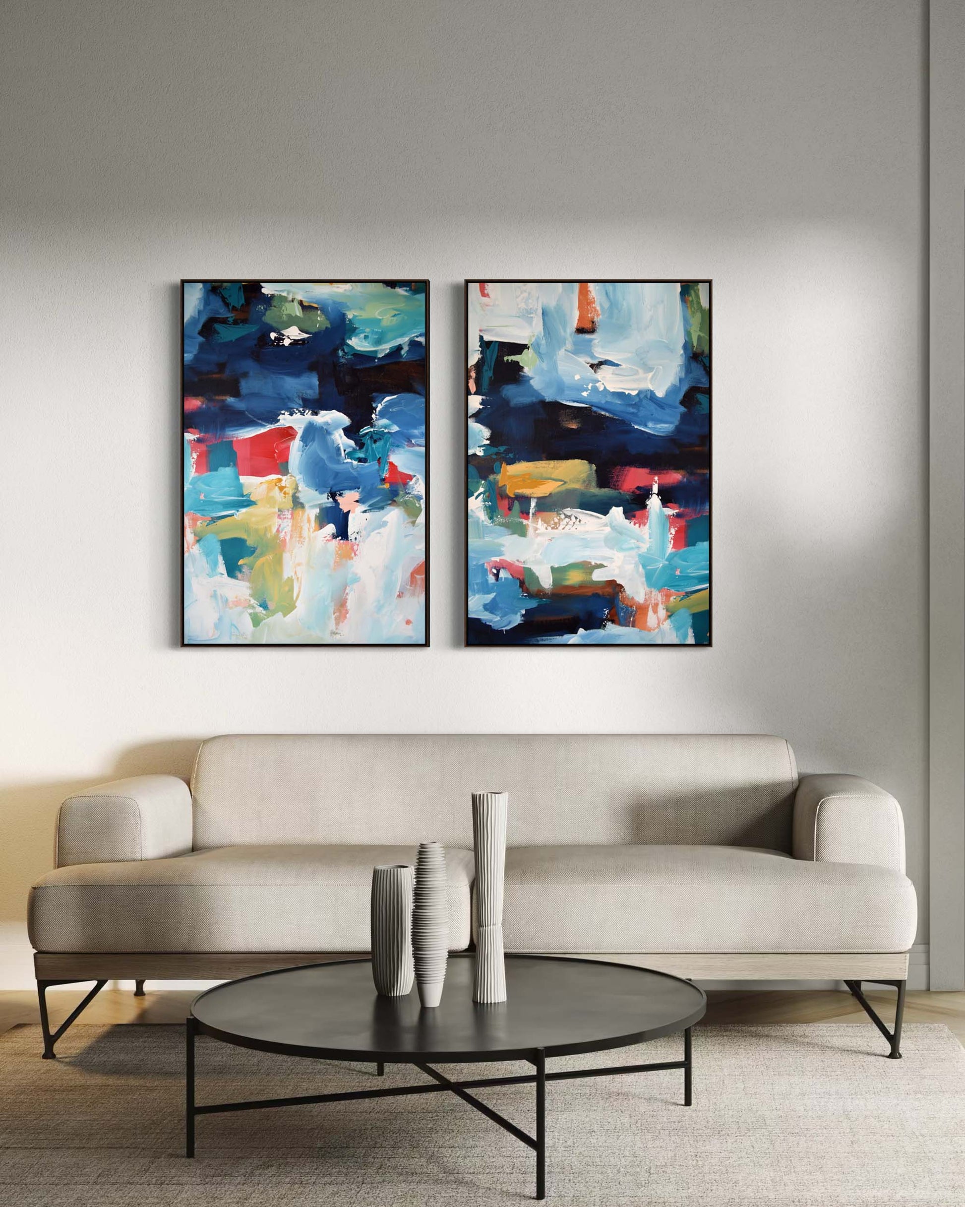 Two abstract paintings above a beige sofa in a living room setting.