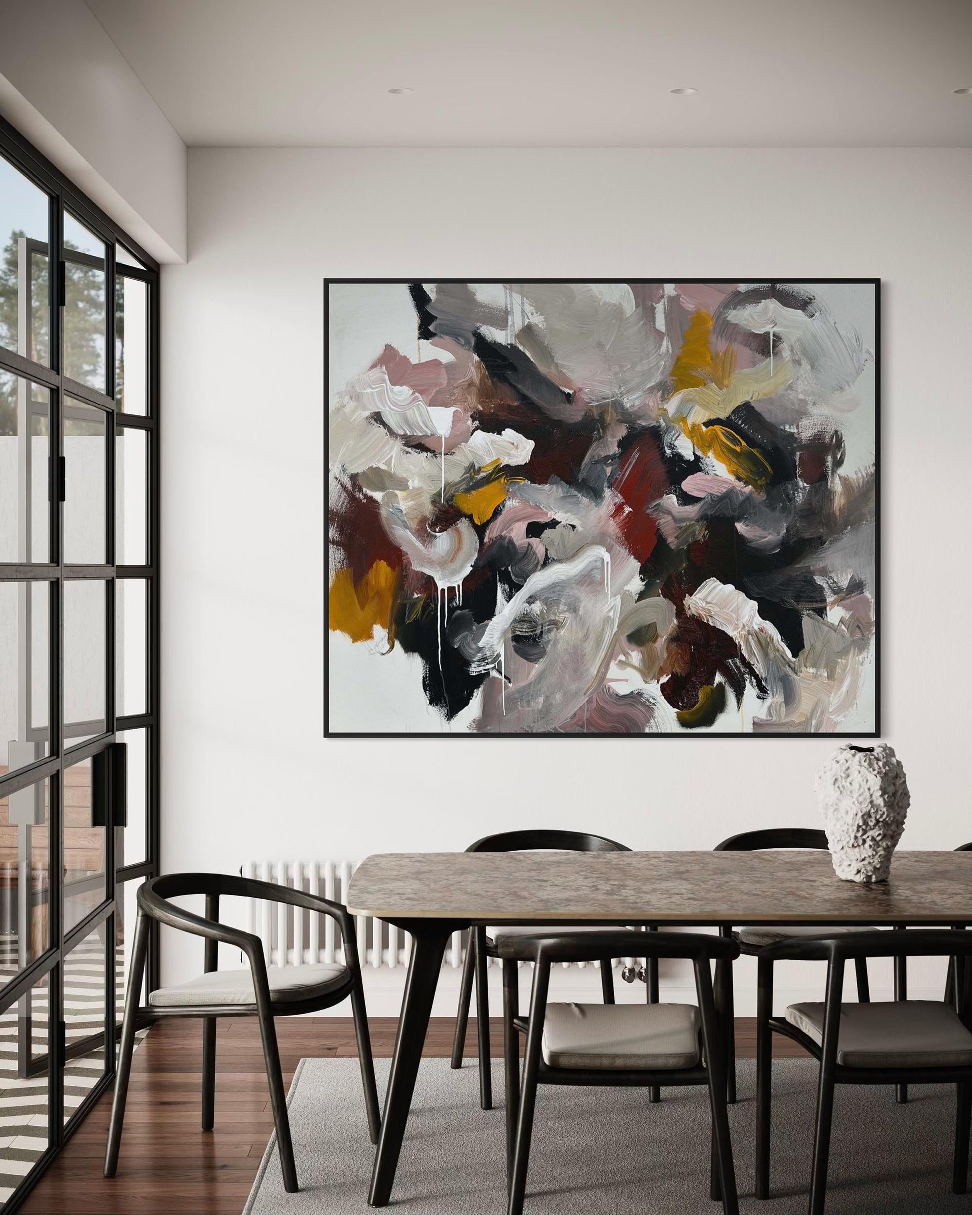 Dining room with a large abstract painting on the wall above a wooden table.