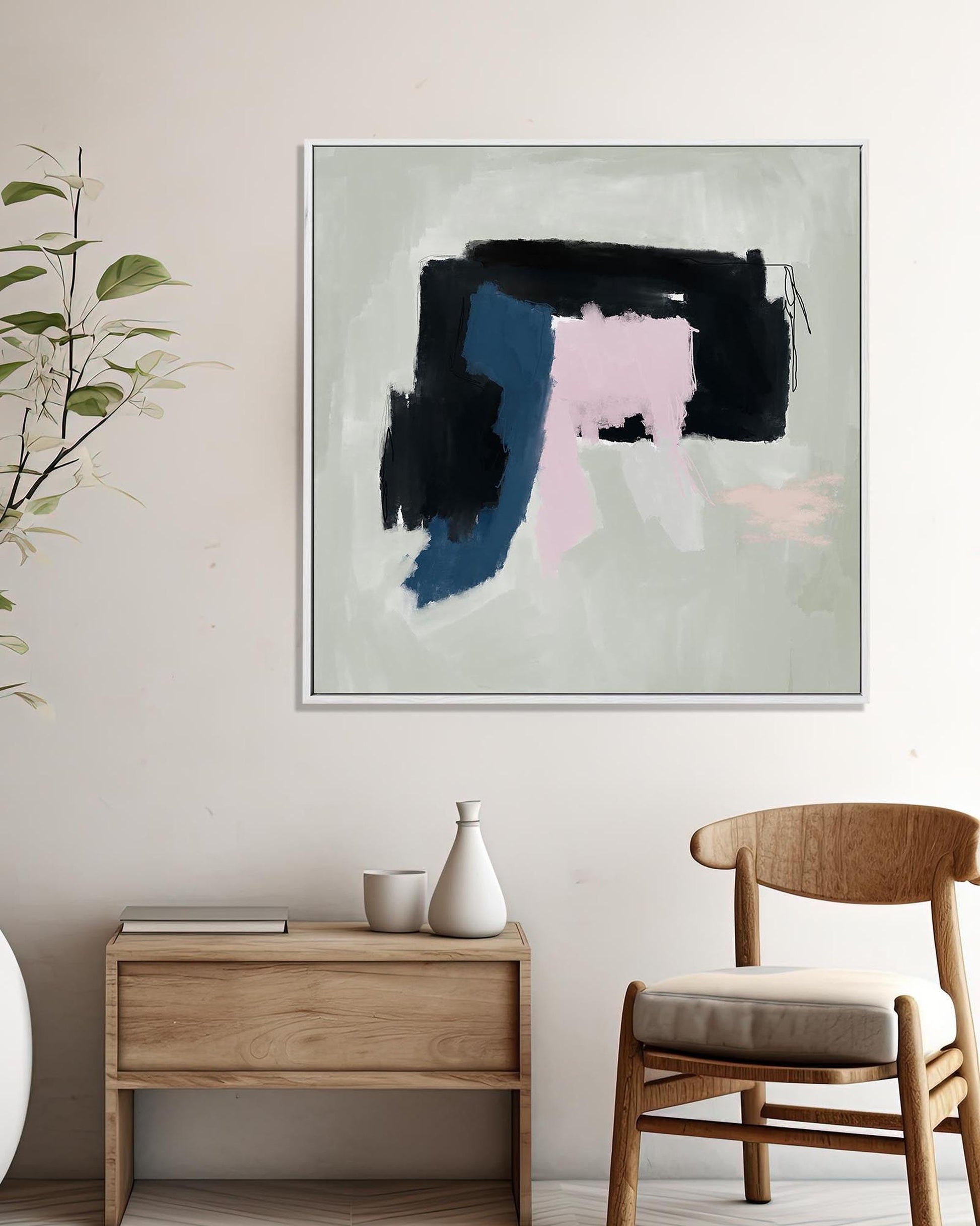 Abstract art piece on a wall in a modern interior setting with a wooden side table and chair.