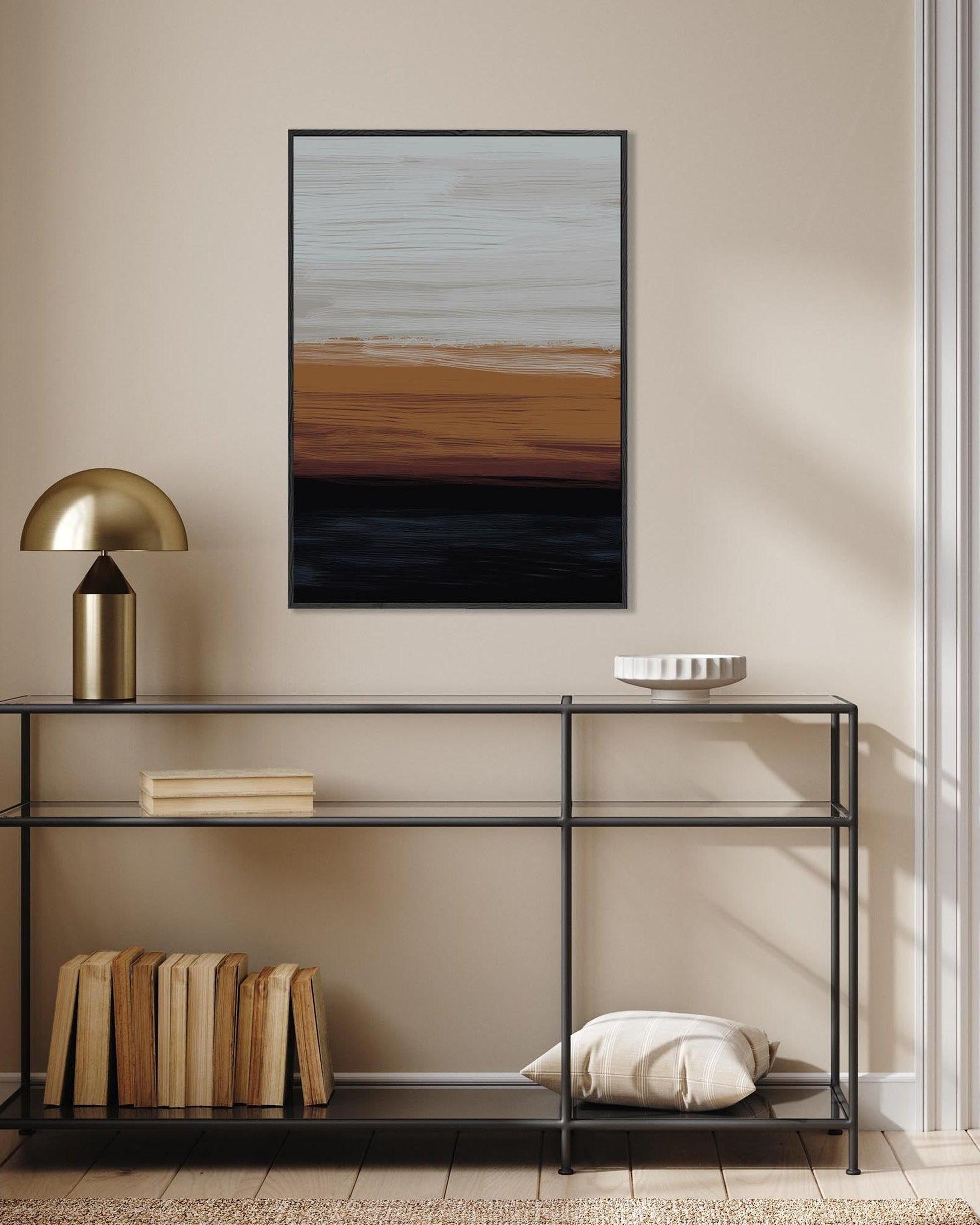 Modern interior with a console table, lamp, books, and abstract painting on a beige wall.