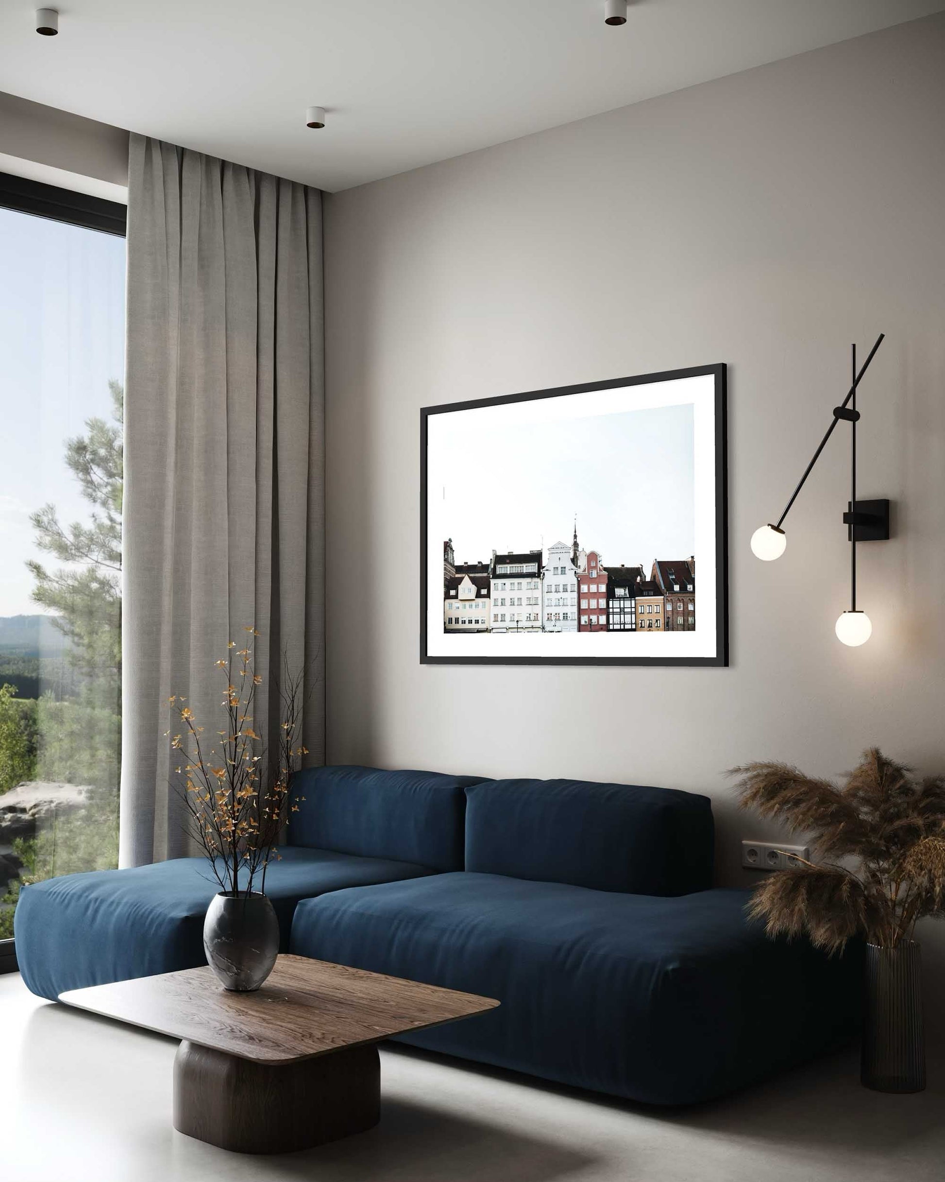 Modern living room with a blue sofa, framed artwork on the wall, and decorative elements.
