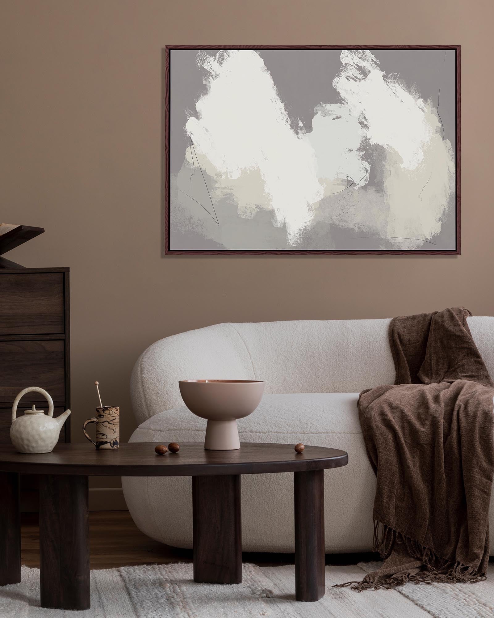 Living room with a white sofa, wooden coffee table, and abstract art on the wall.