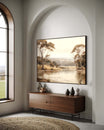 Modern interior with a large landscape painting above a wooden sideboard.
