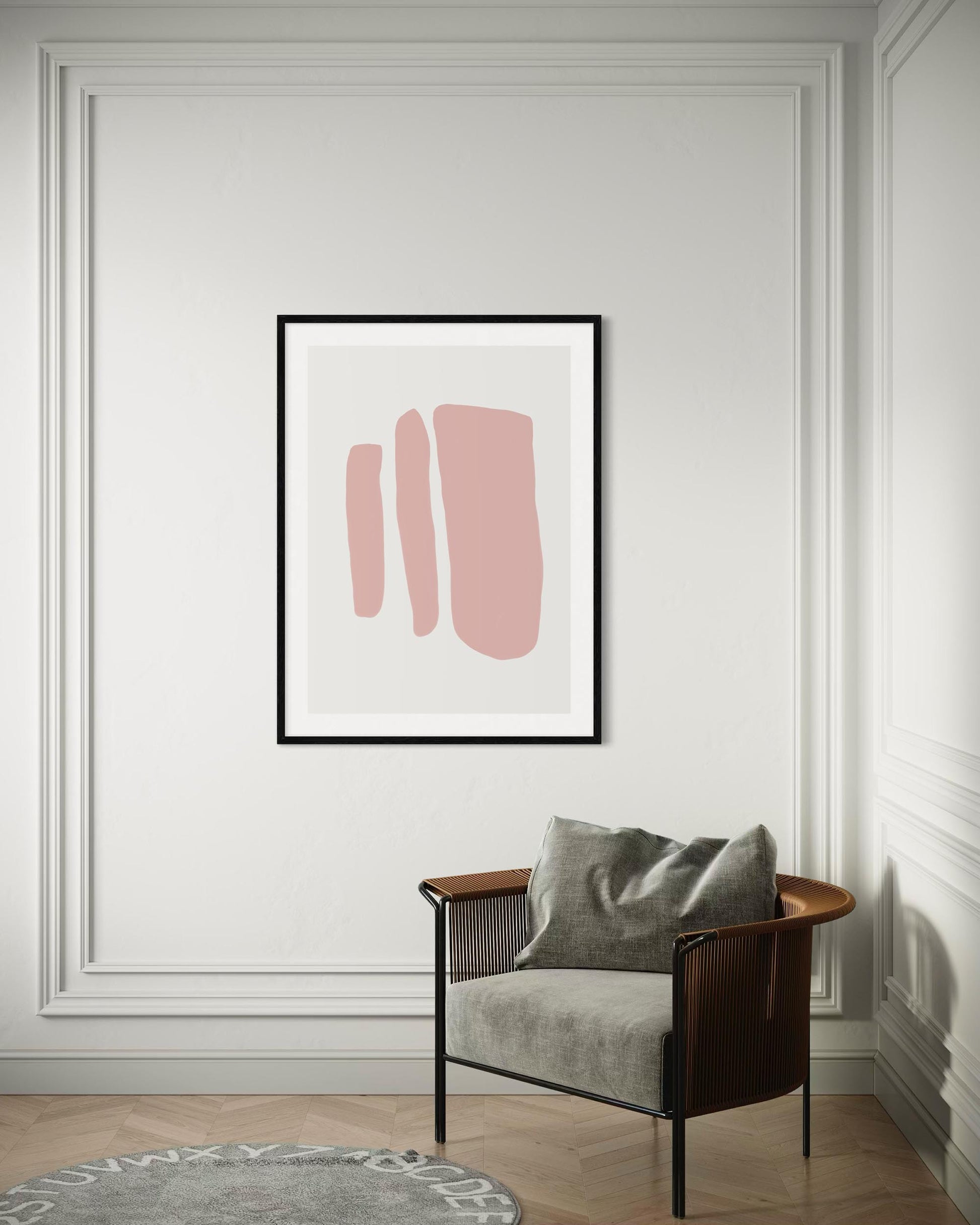 Framed abstract art with pink shapes on a wall above a chair.