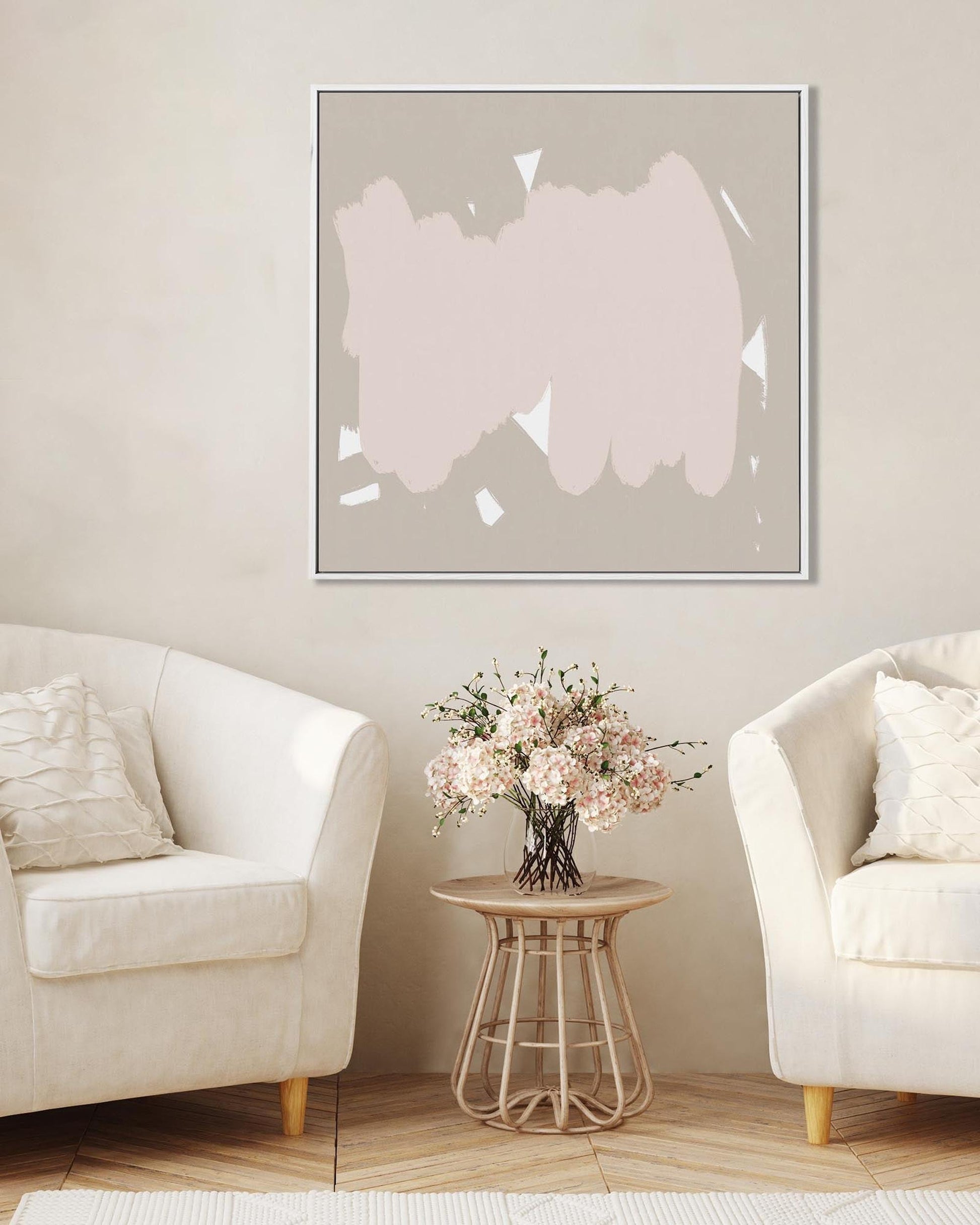 Modern living room with abstract art, white chairs, and a small table with flowers.