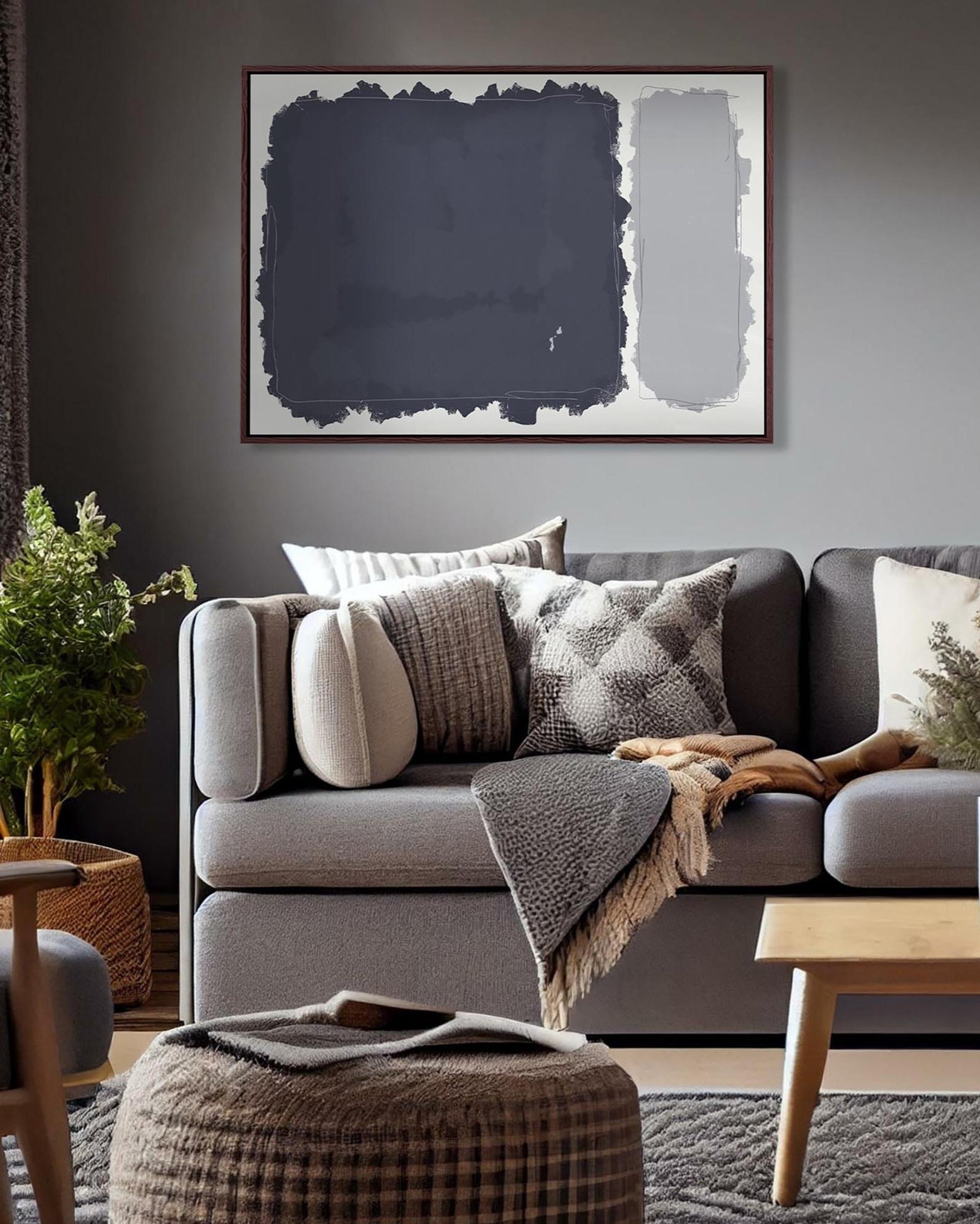 Gray sofa with decorative pillows and a blanket in a living room setting.