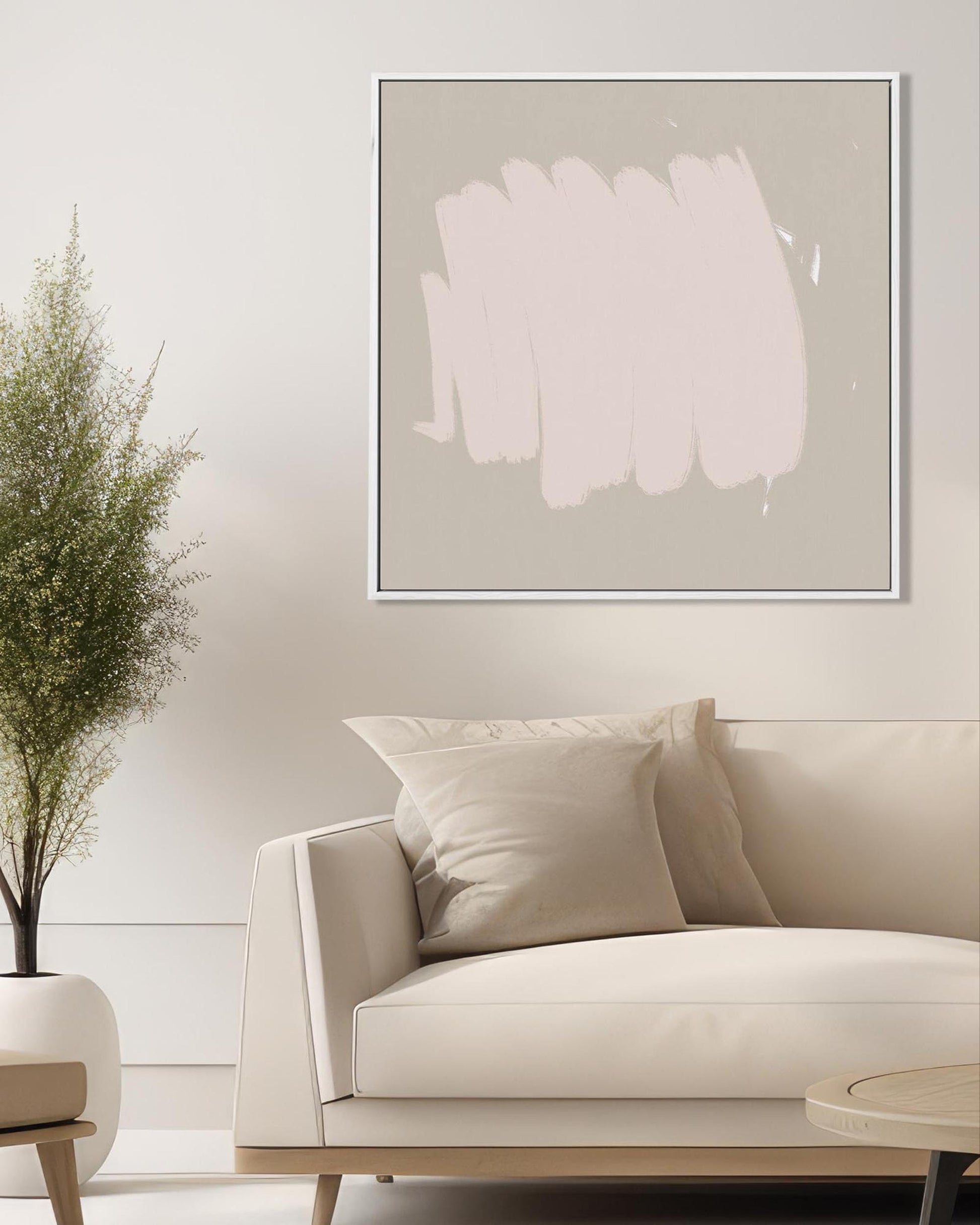 Beige sofa with decorative pillows in a room with abstract art on the wall.