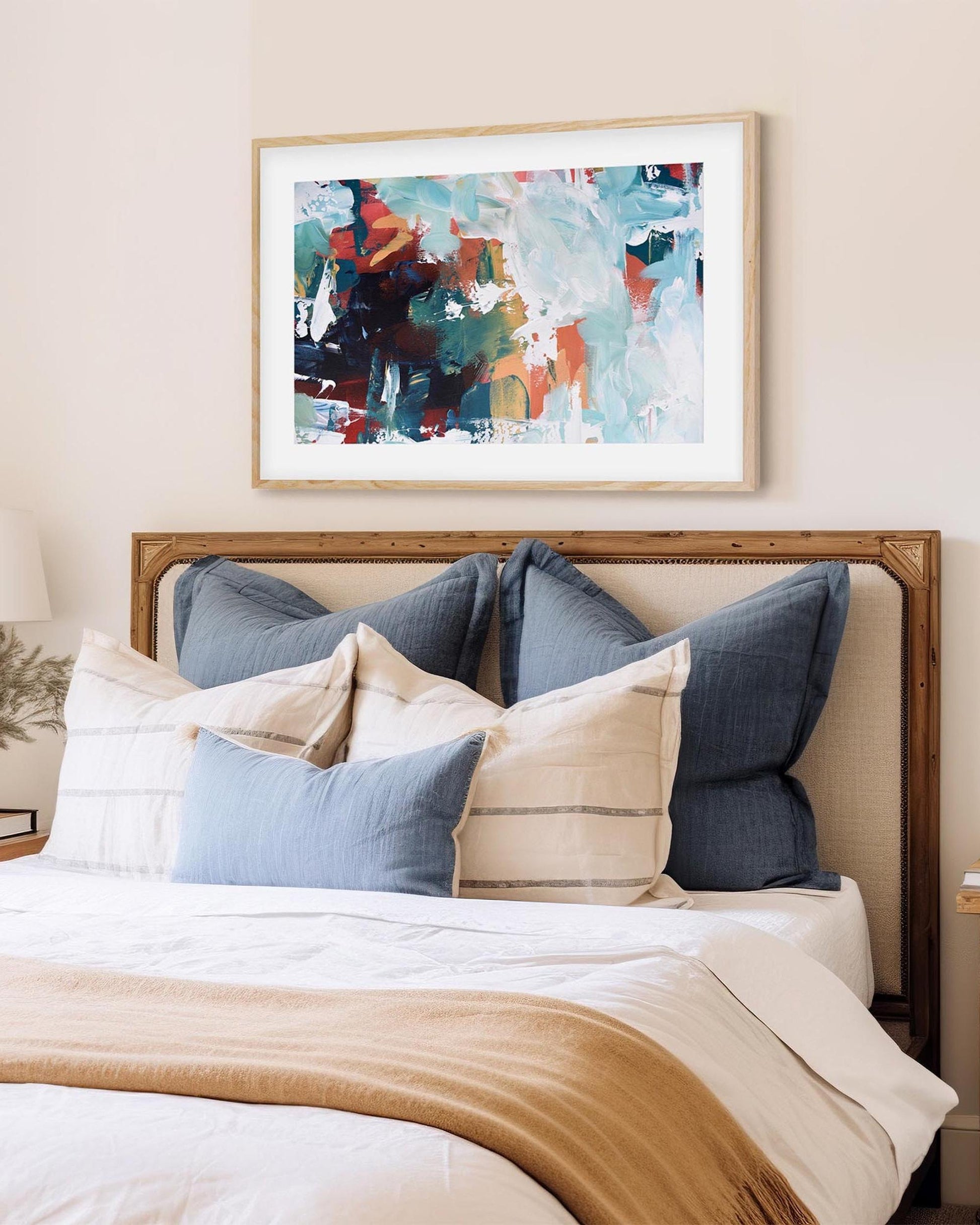 abstract art print in an oak frame above bed