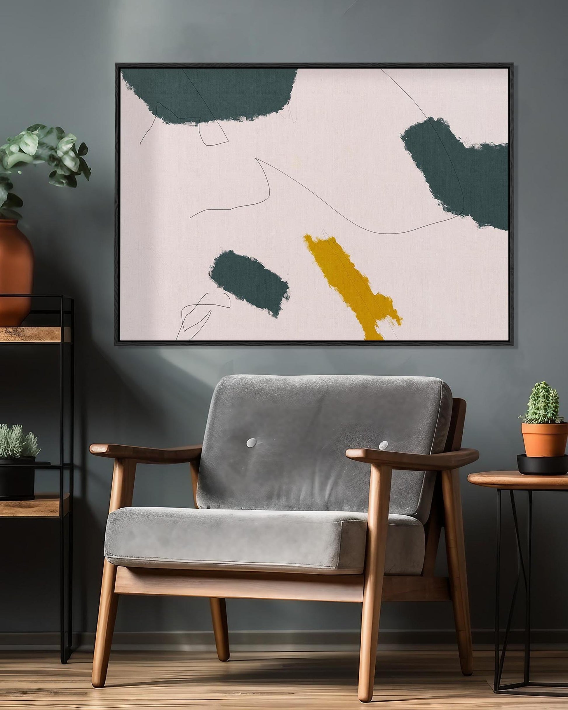 Modern living room with a gray armchair, abstract art, and decorative plants.