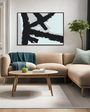 Modern living room with beige sectional sofa, round wooden coffee table, and abstract art on the wall.