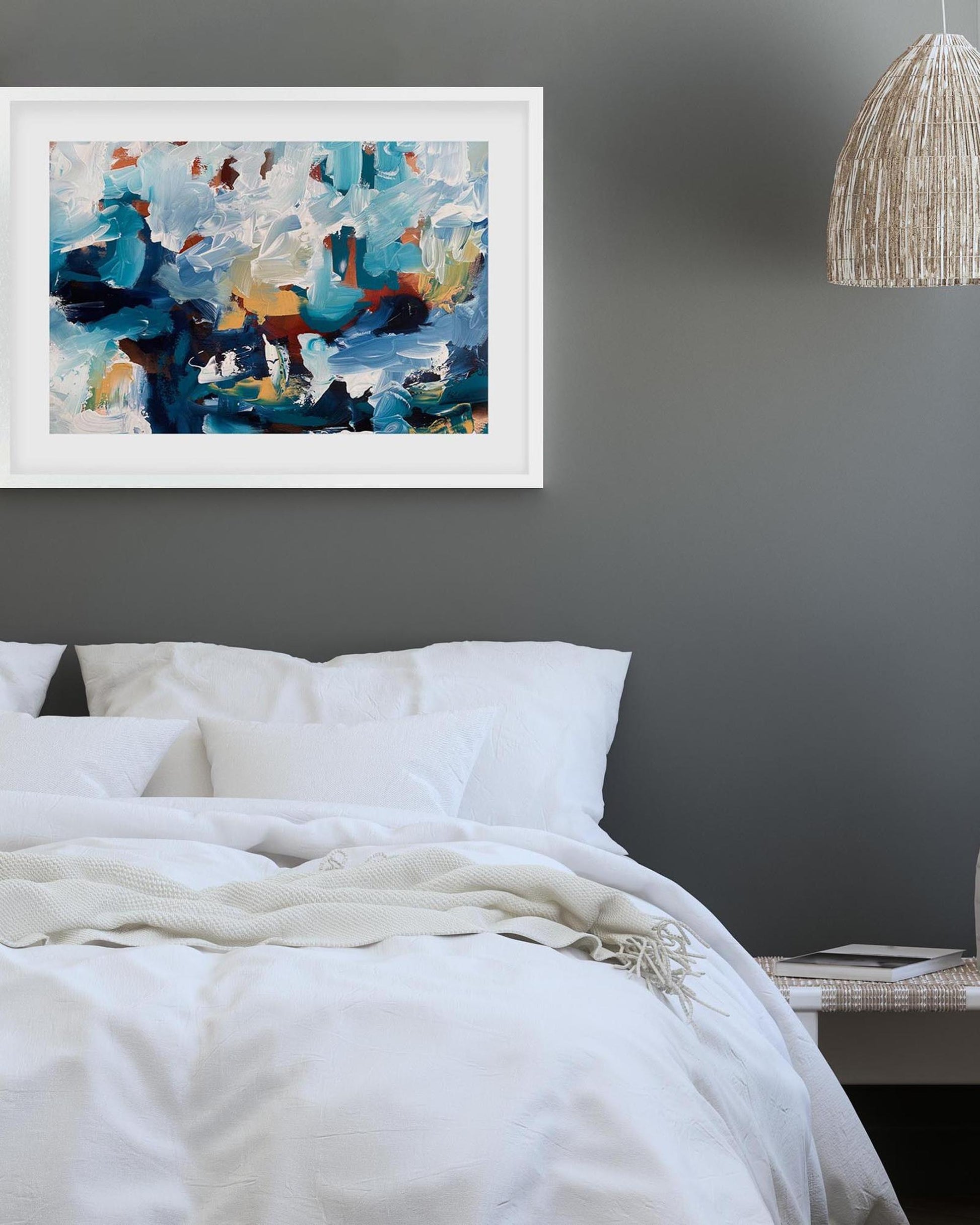 Abstract painting on a wall above a bed with white bedding.
