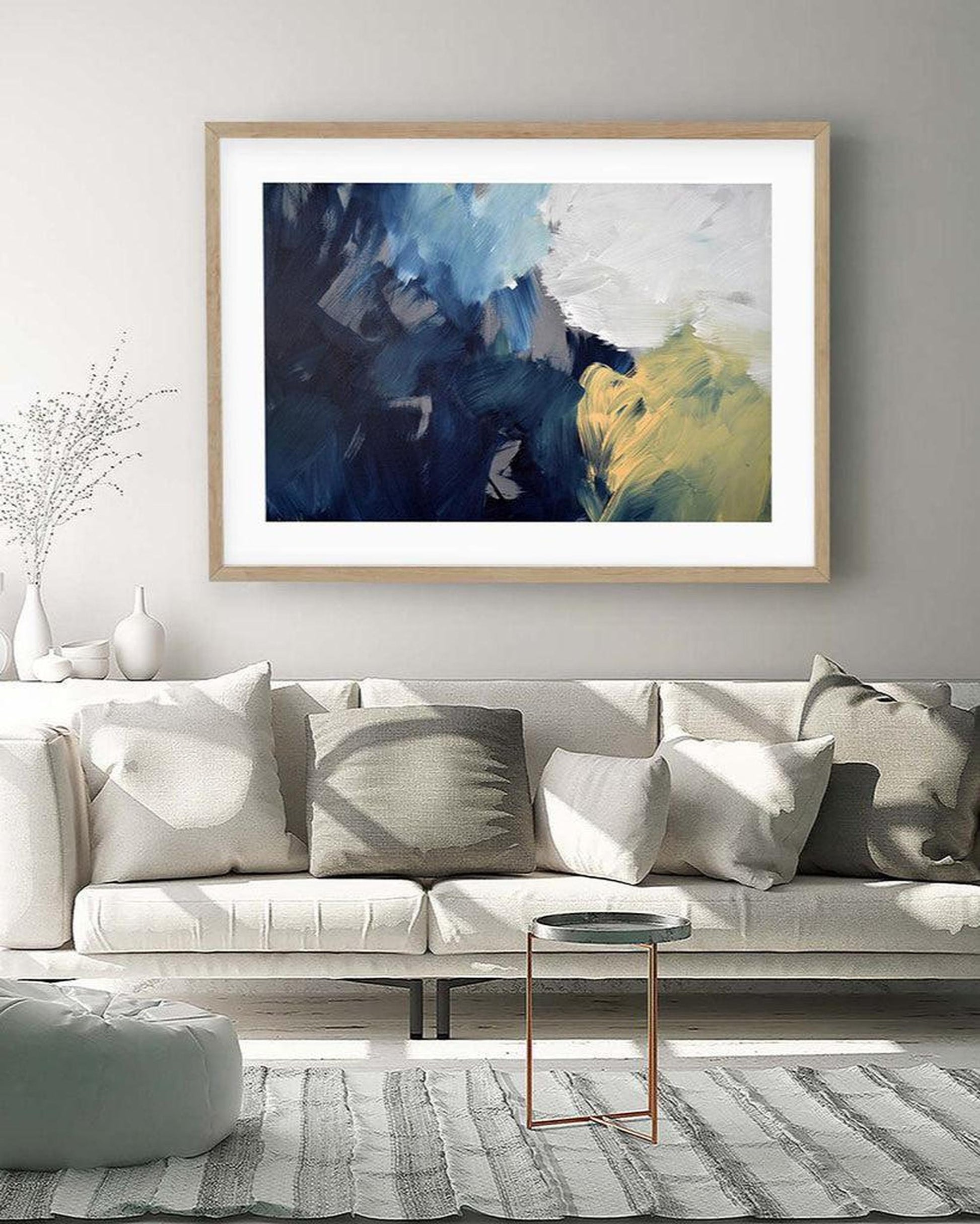 Framed abstract art above a sofa in a living room setting
