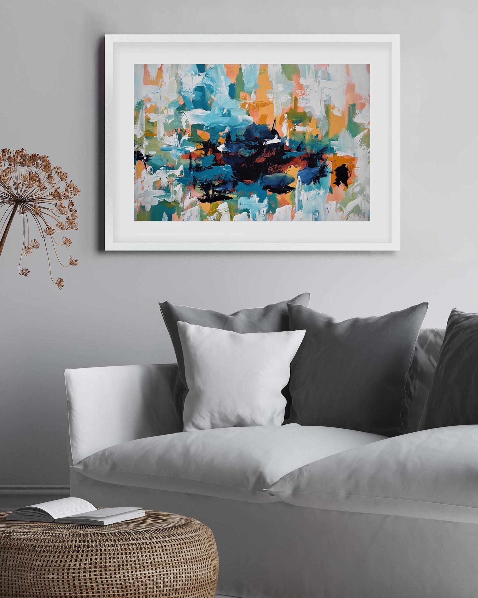 Abstract art print on a gray wall above a sofa with decorative pillows.