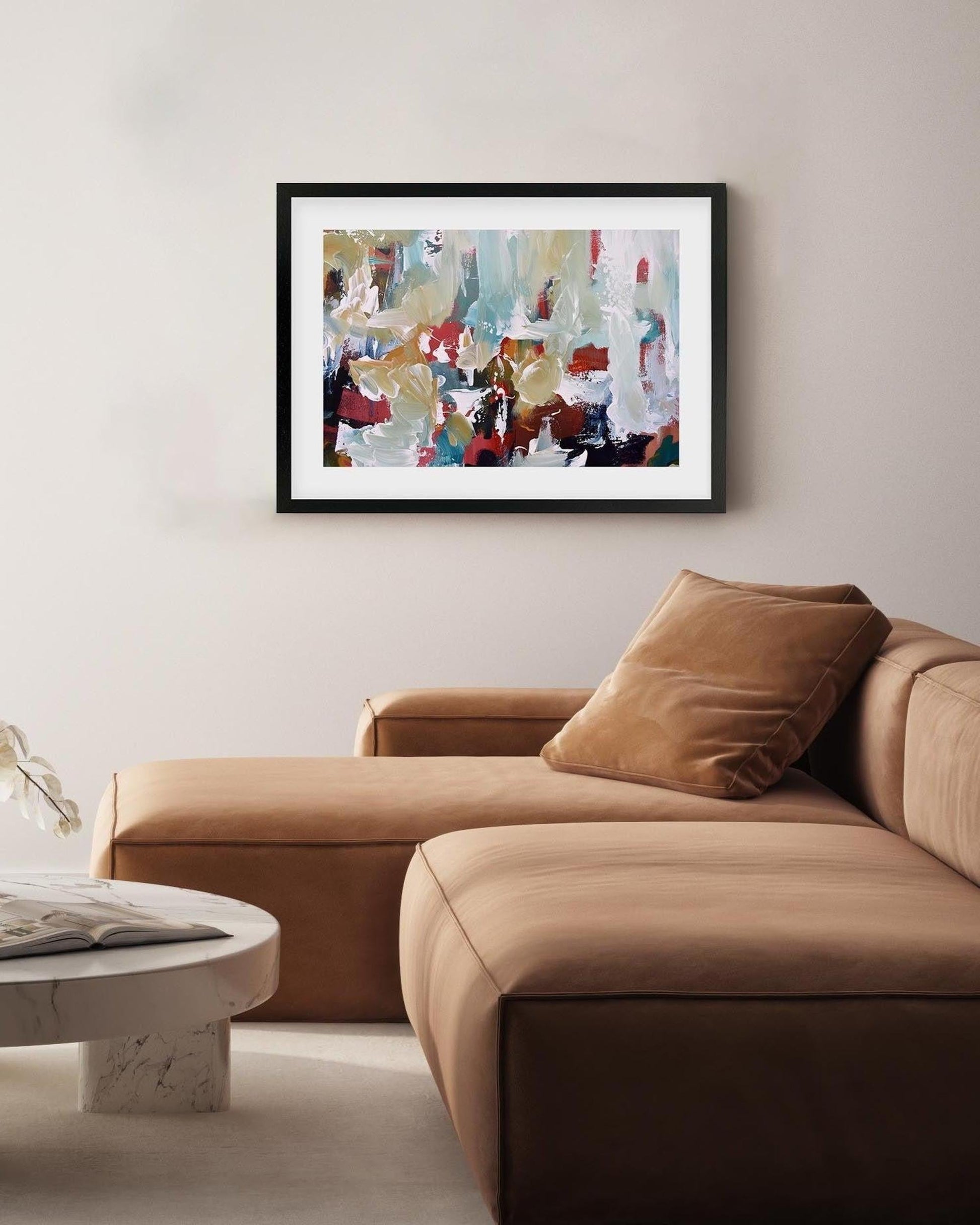 Modern living room with a brown sectional sofa, round coffee table, and abstract art on the wall.